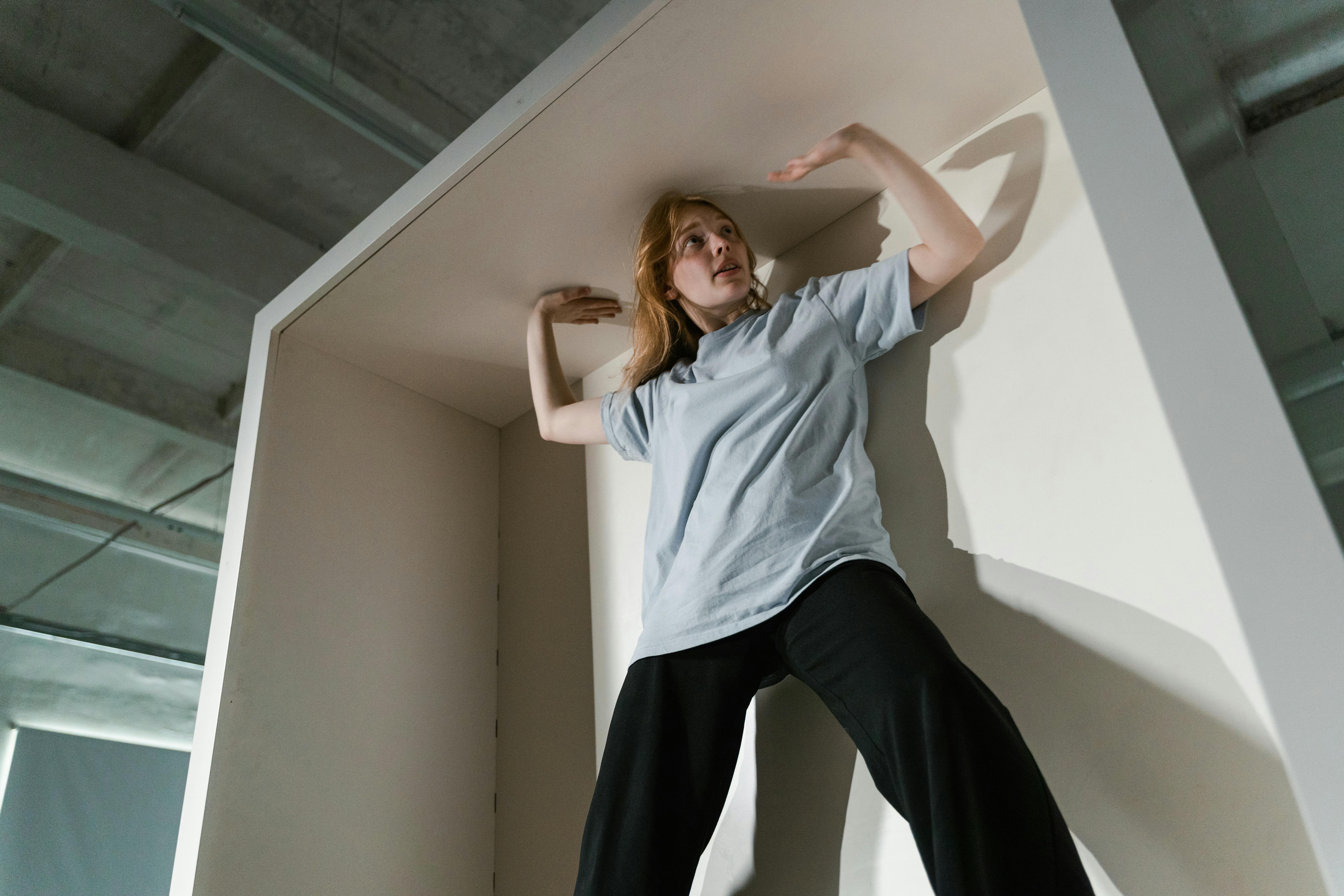 Woman experiencing claustrophobia in a confined cabinet space, illustrating the psychological impact of architecture.