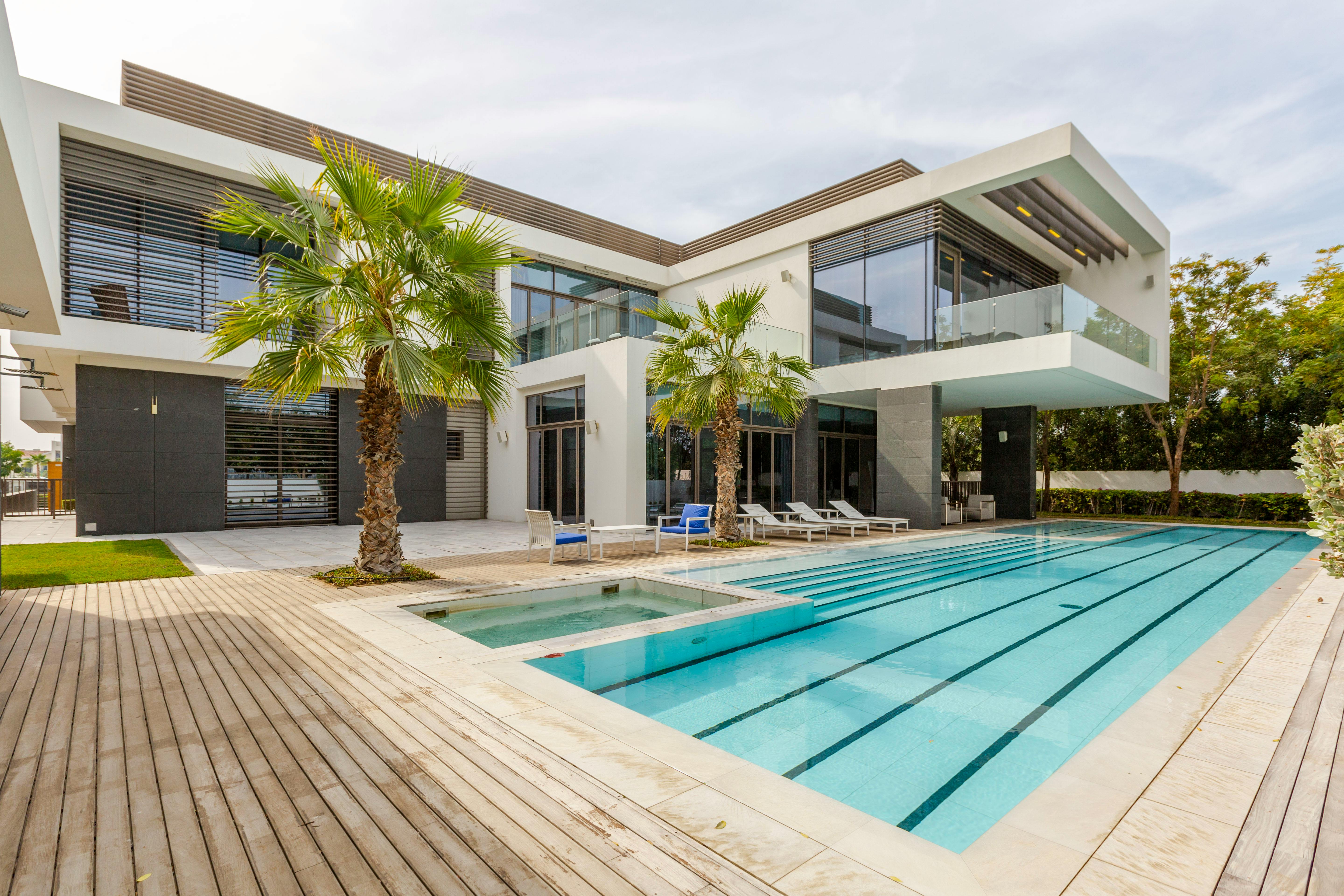Concrete villa house next to a swimming pool in Dubai, showcasing modern design.