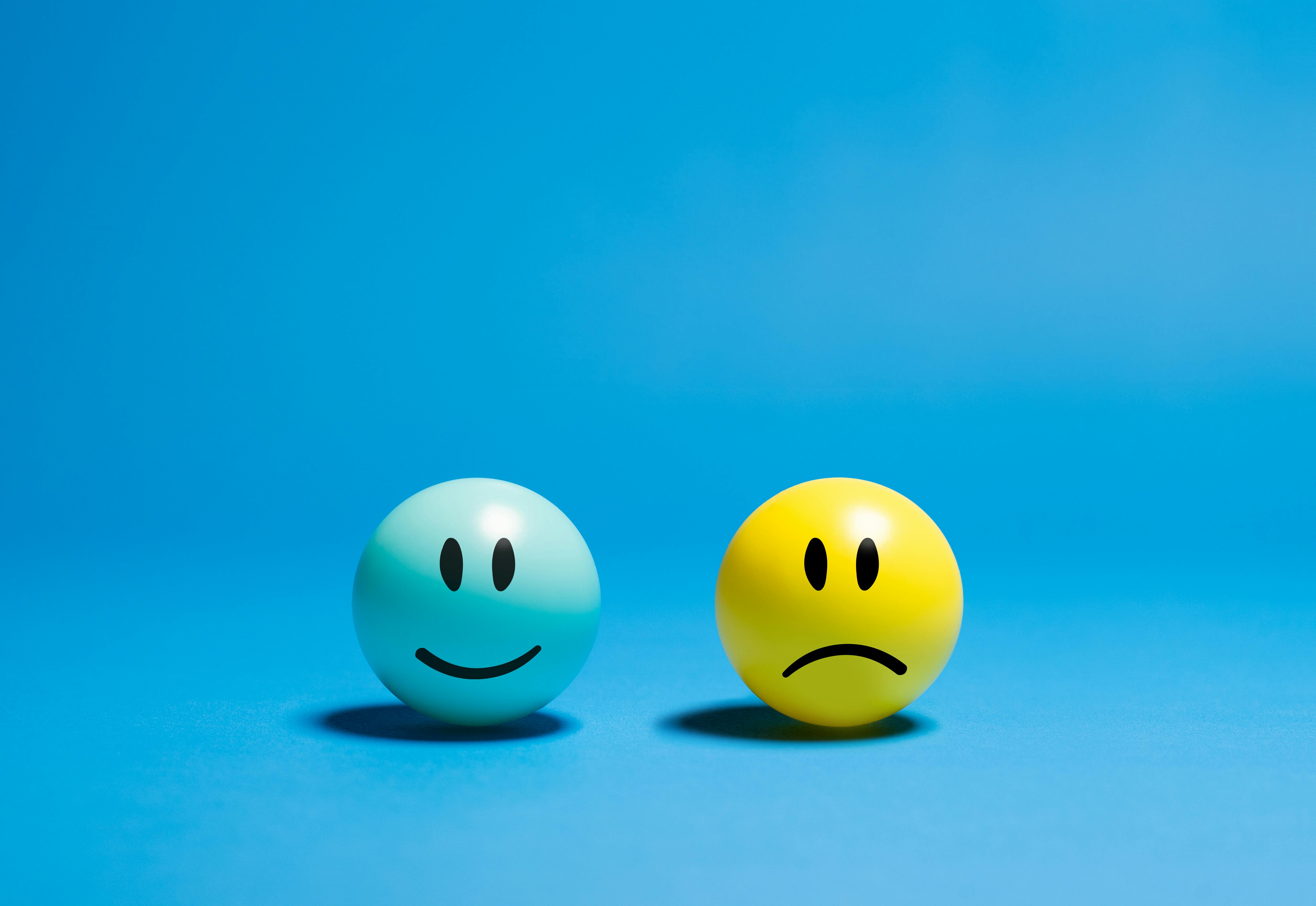  Contrasting emotions on smiley balls, yellow neutral and blue smiling.