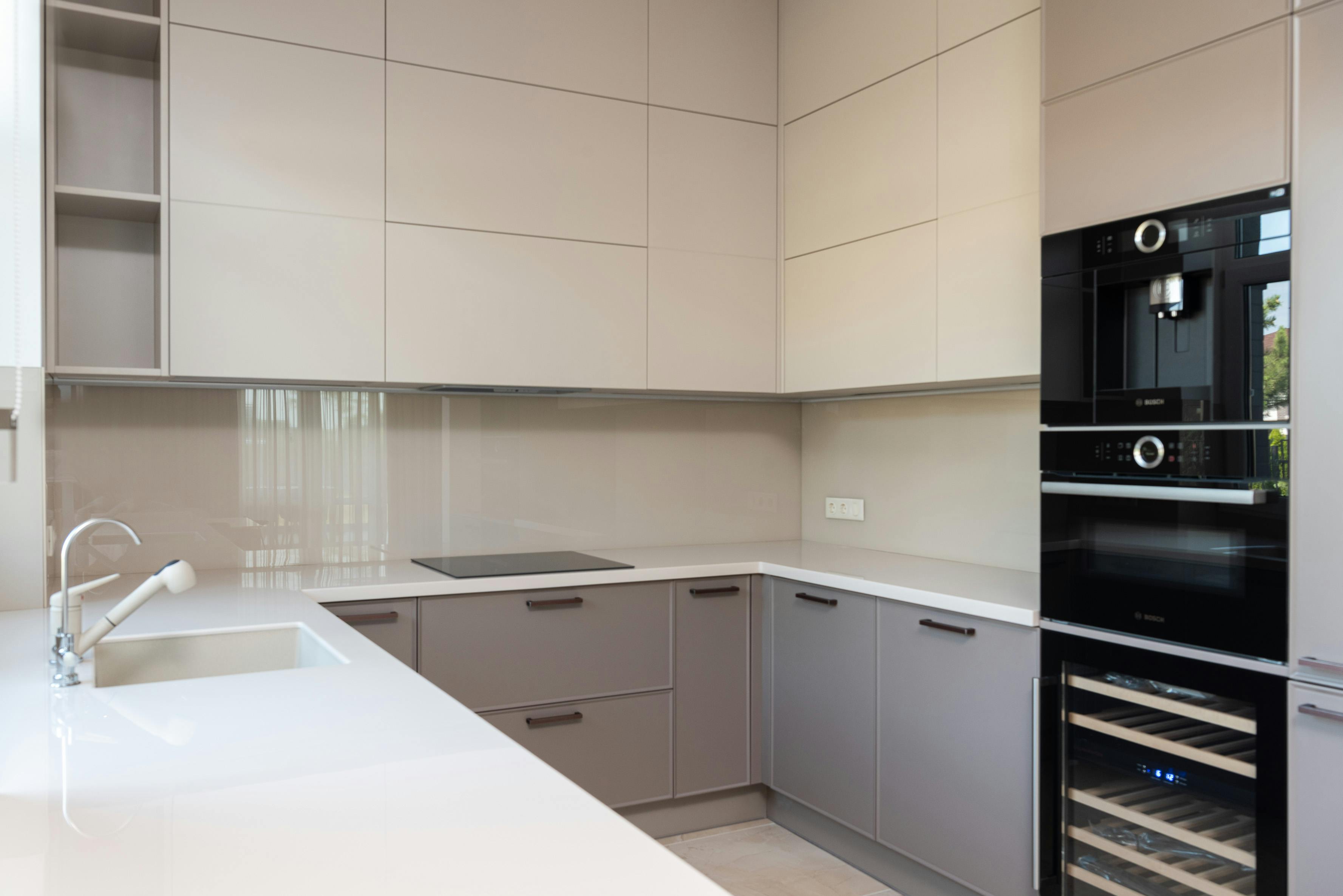 Contemporary kitchen with cream cabinets, wood flooring, and stainless steel appliances.