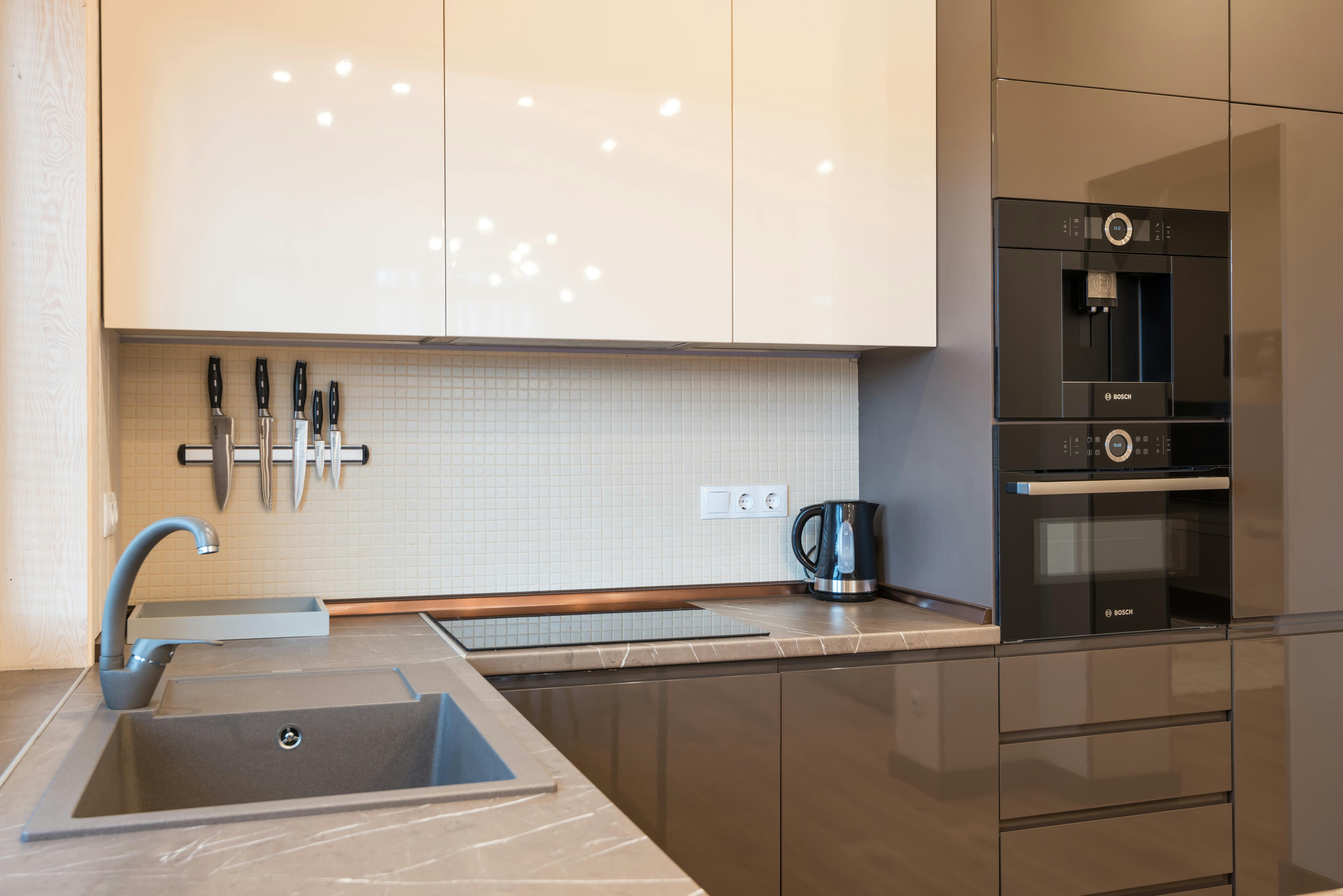 Kitchen with dark cream cabinets and modern appliances, blending style and functionality.