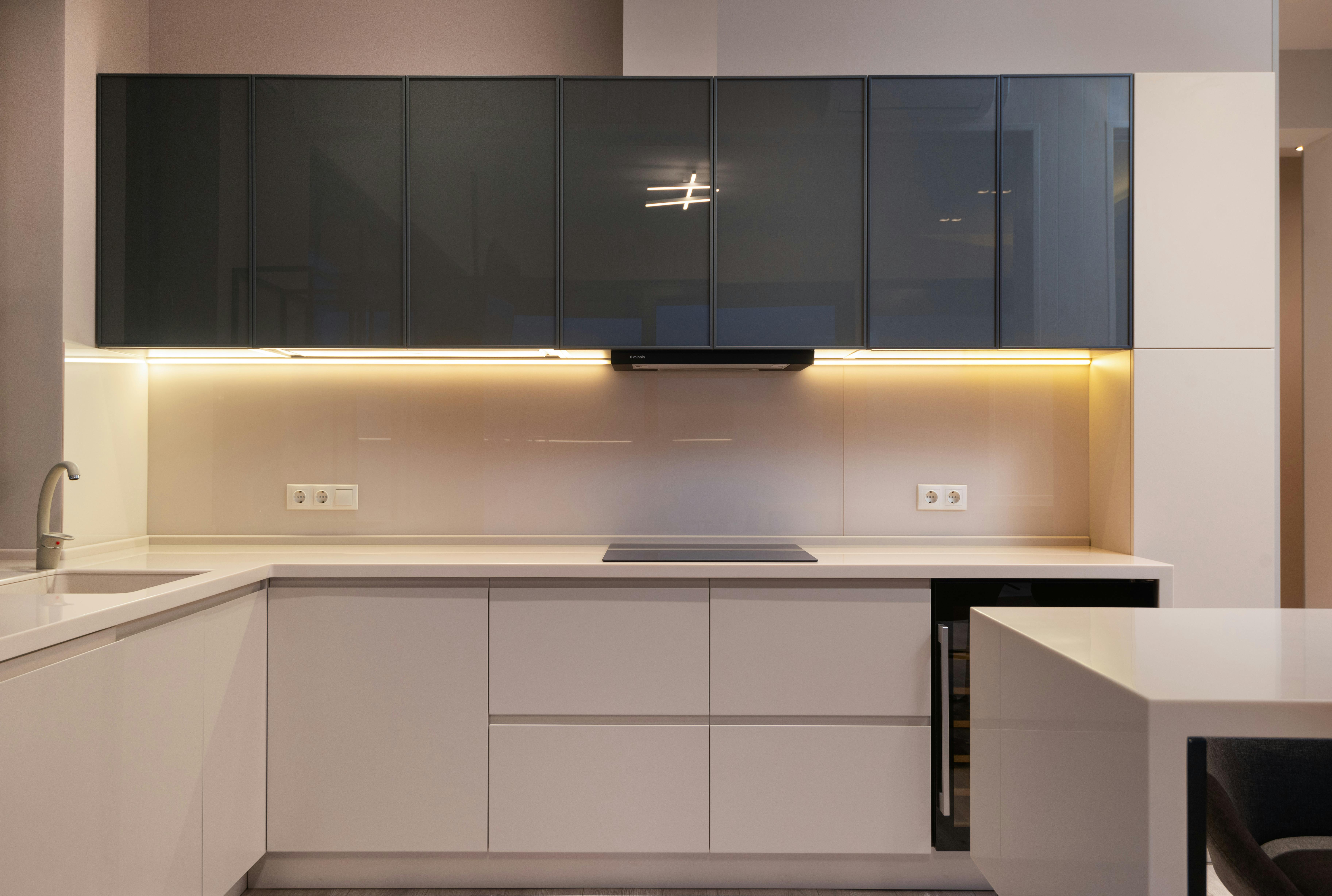 Spacious minimalist kitchen with dark modern furniture, designed for a sleek and open layout.