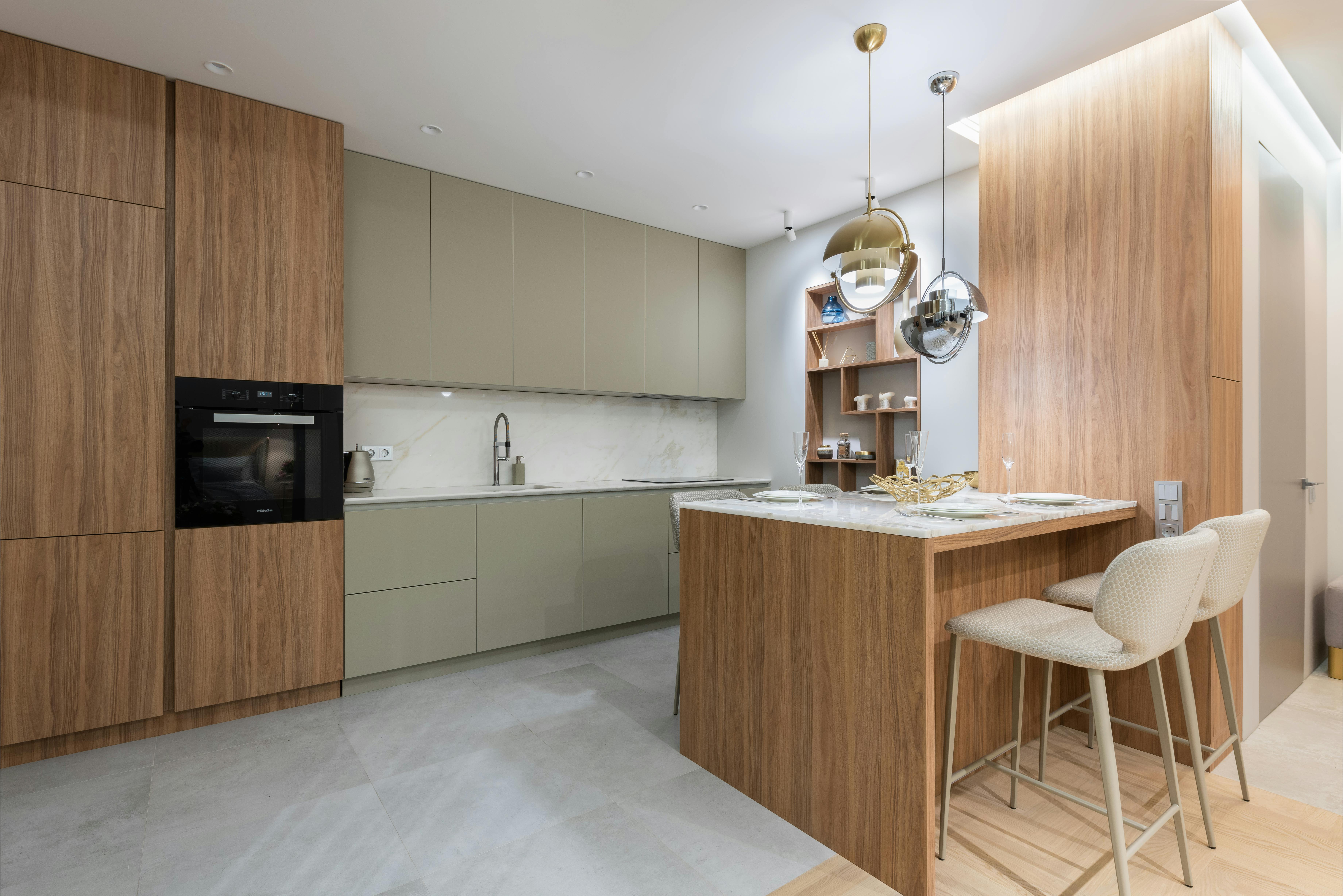 Kitchen with earthy green accents and cream cabinets, creating a natural and calming atmosphere.