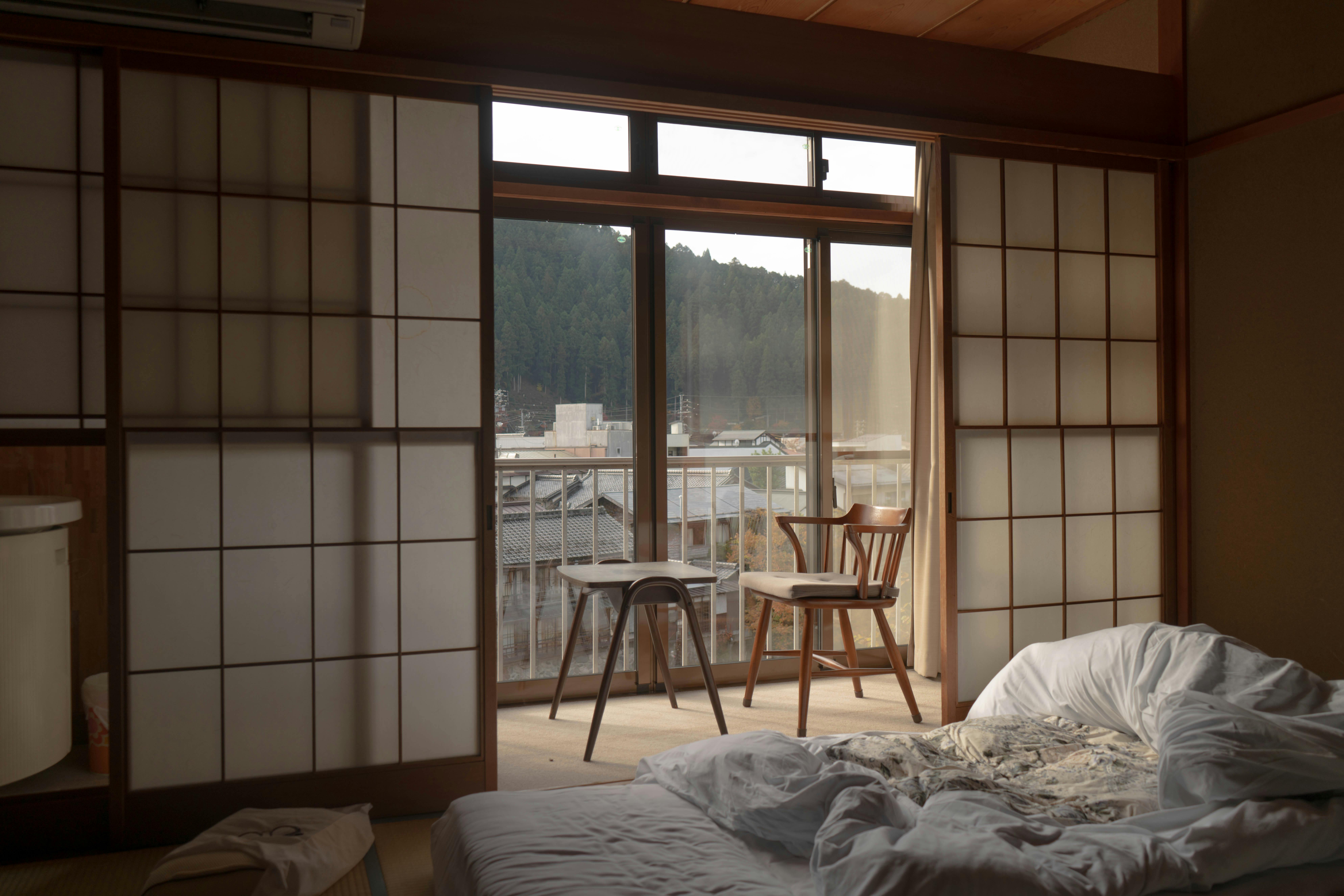 Empty wooden table and chair beside a glass sliding door in a bedroom in Gujō, Gifu, Japan.
