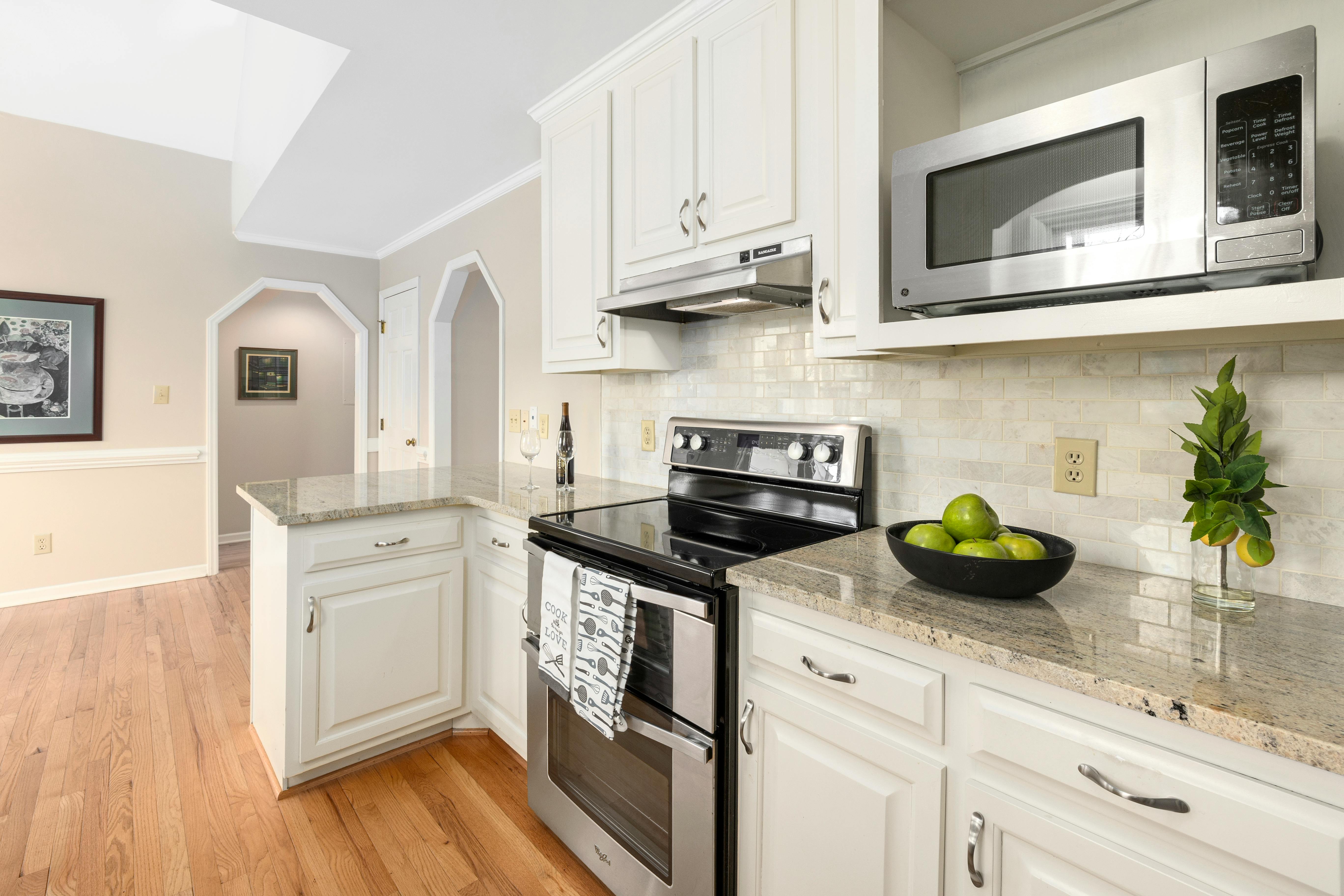Modern kitchen interior with cream cabinets and black hardware, creating a bold, stylish contrast.