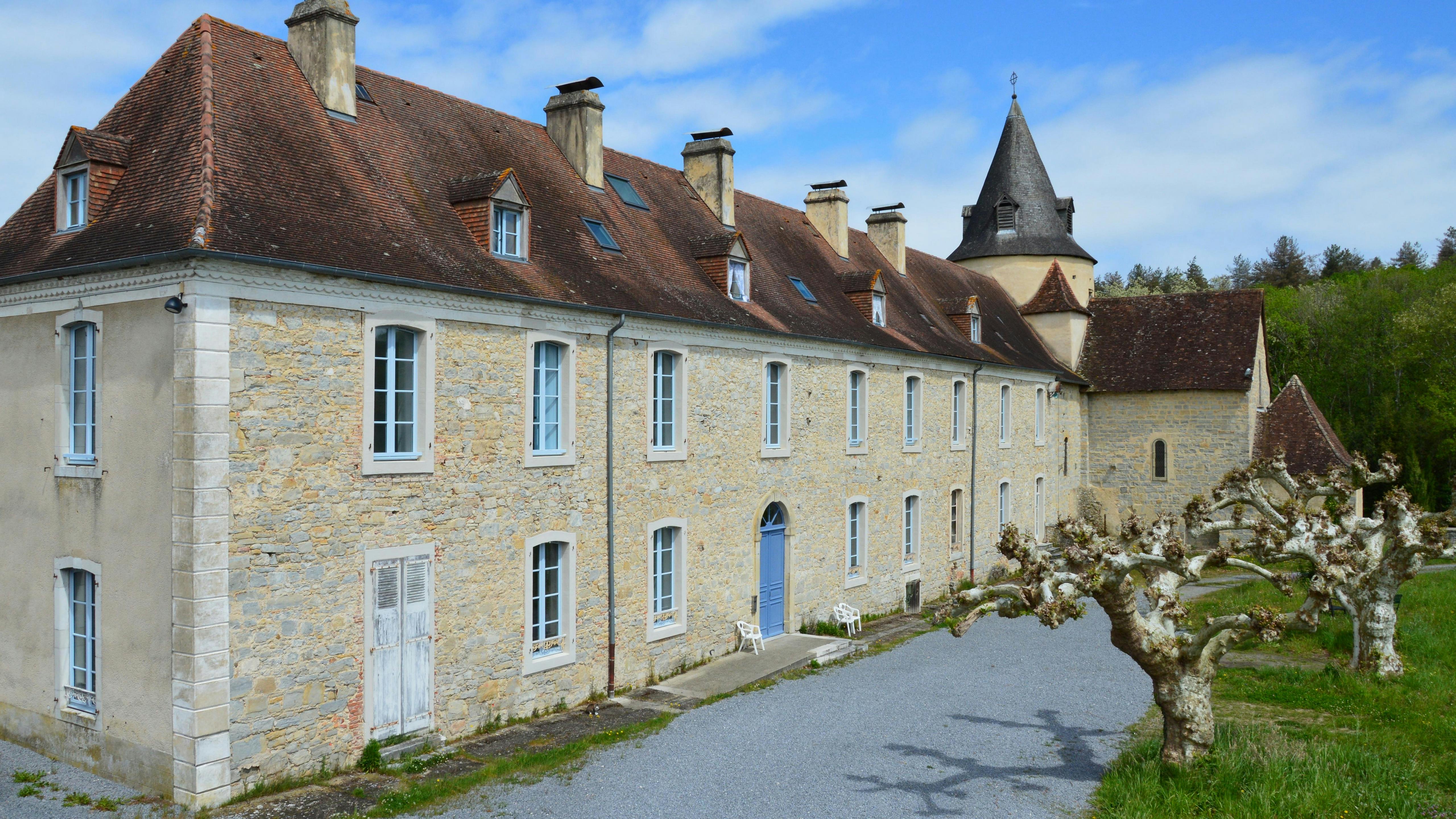 View of the medieval Abbey of Sauvelade in France, showcasing Romanesque architecture.