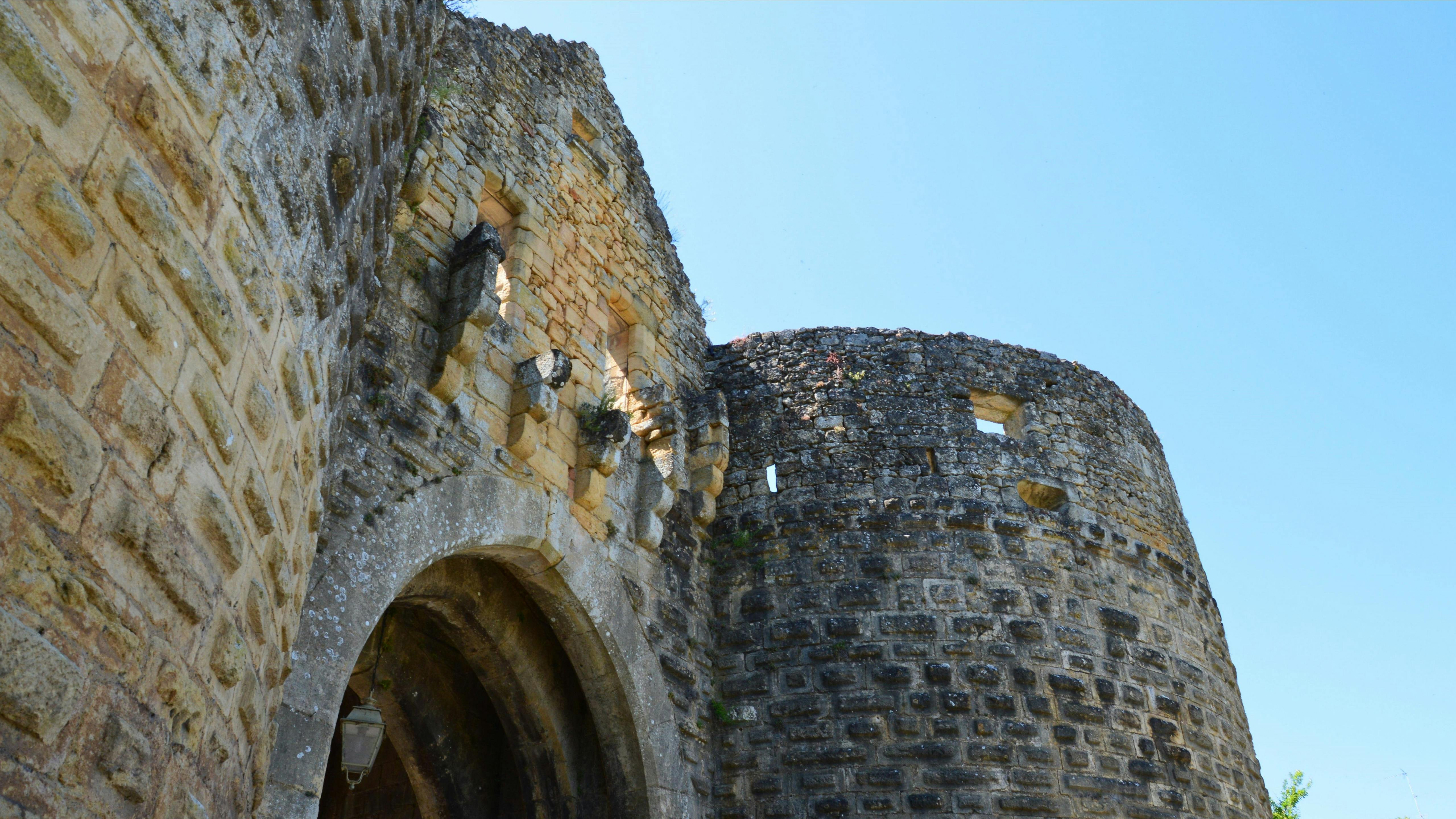 Low angle view of a medieval castle with a prominent tower, showcasing its imposing structure.