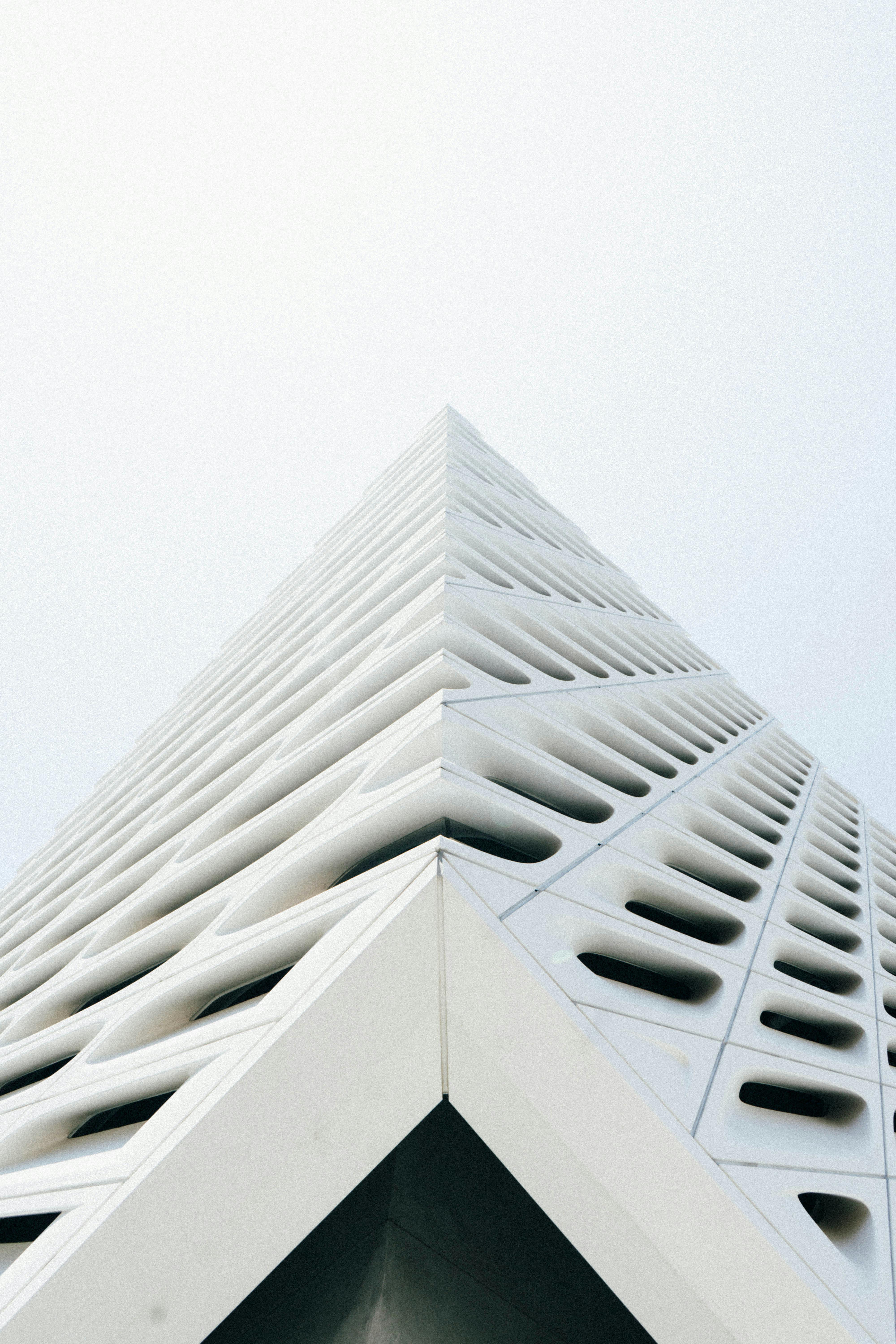 Low angle view of a white modern building in Los Angeles, emphasizing sleek lines and minimalist design.