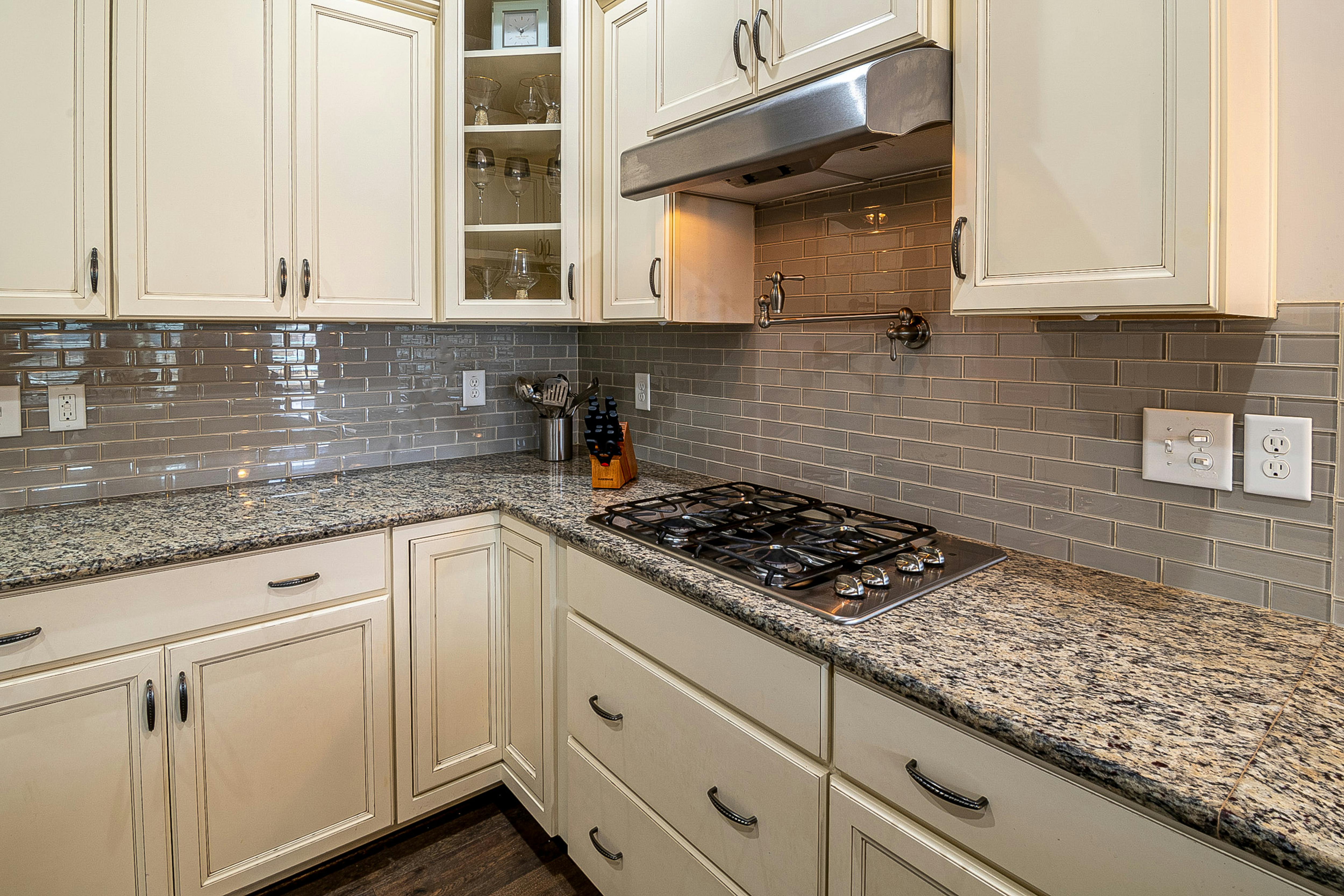 Cream Shaker-style kitchen cabinets with stainless steel faucet.