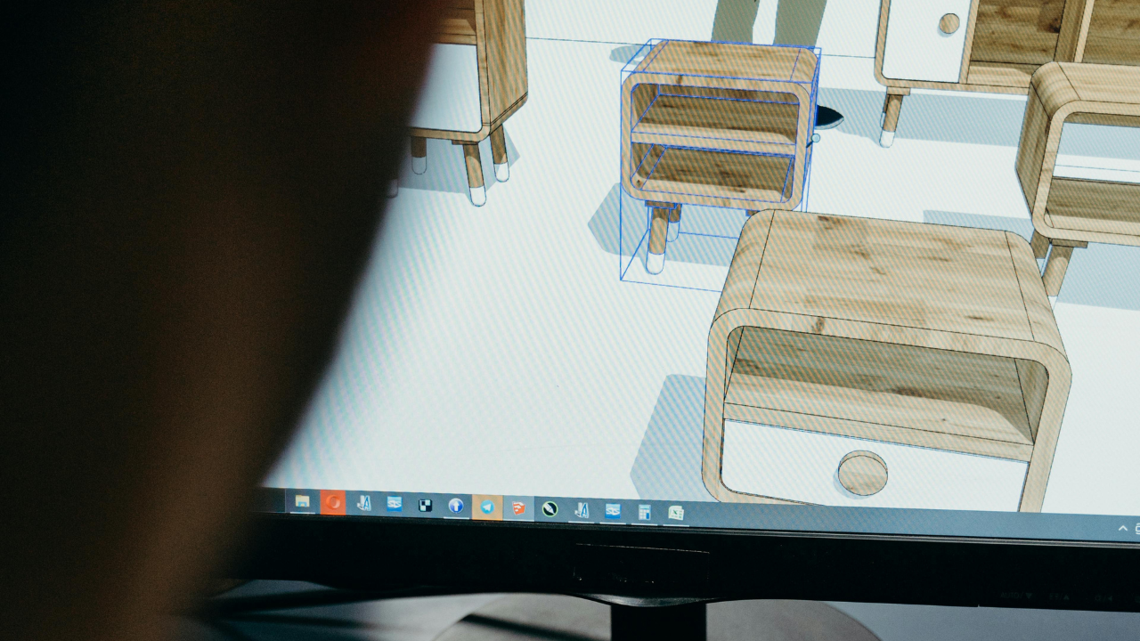 An architecture student working on SketchUp, browsing a digital furniture library on a laptop.
