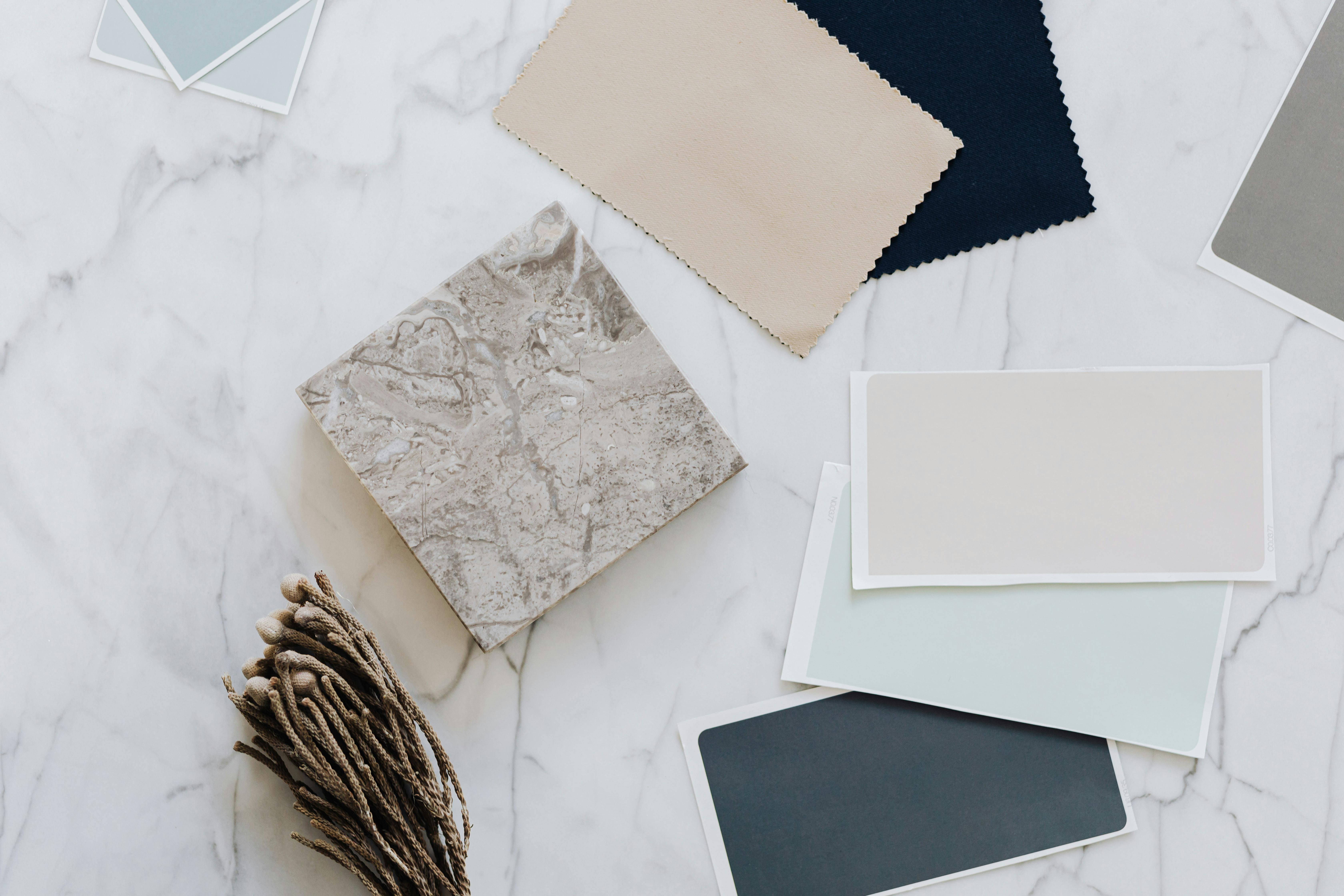 Assorted paper, fabric, and craft materials in neutral tones, exploring texture and material in architectural psychology.