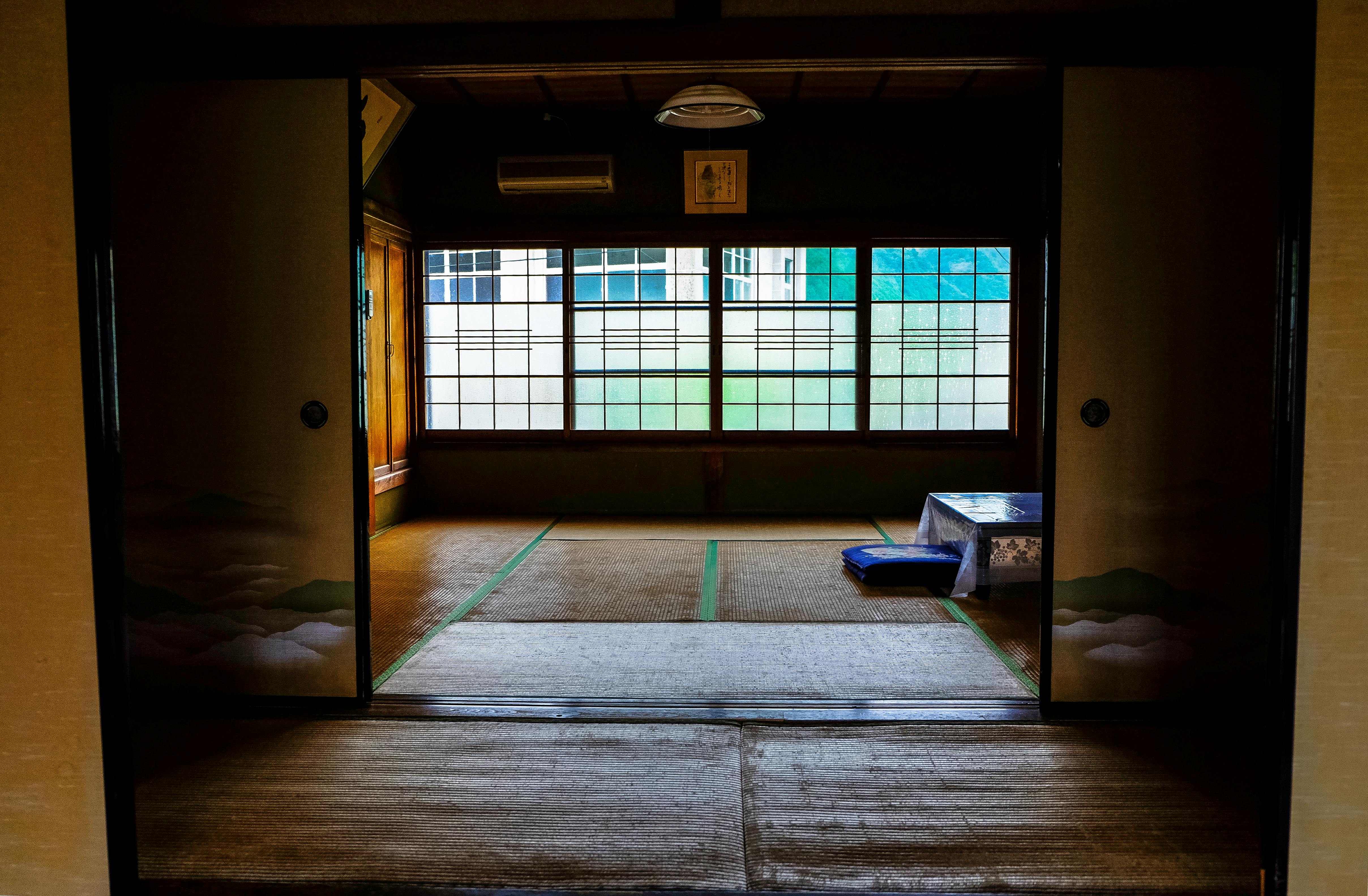 Traditional Japanese room with a table and windows, reflecting minimalist design.