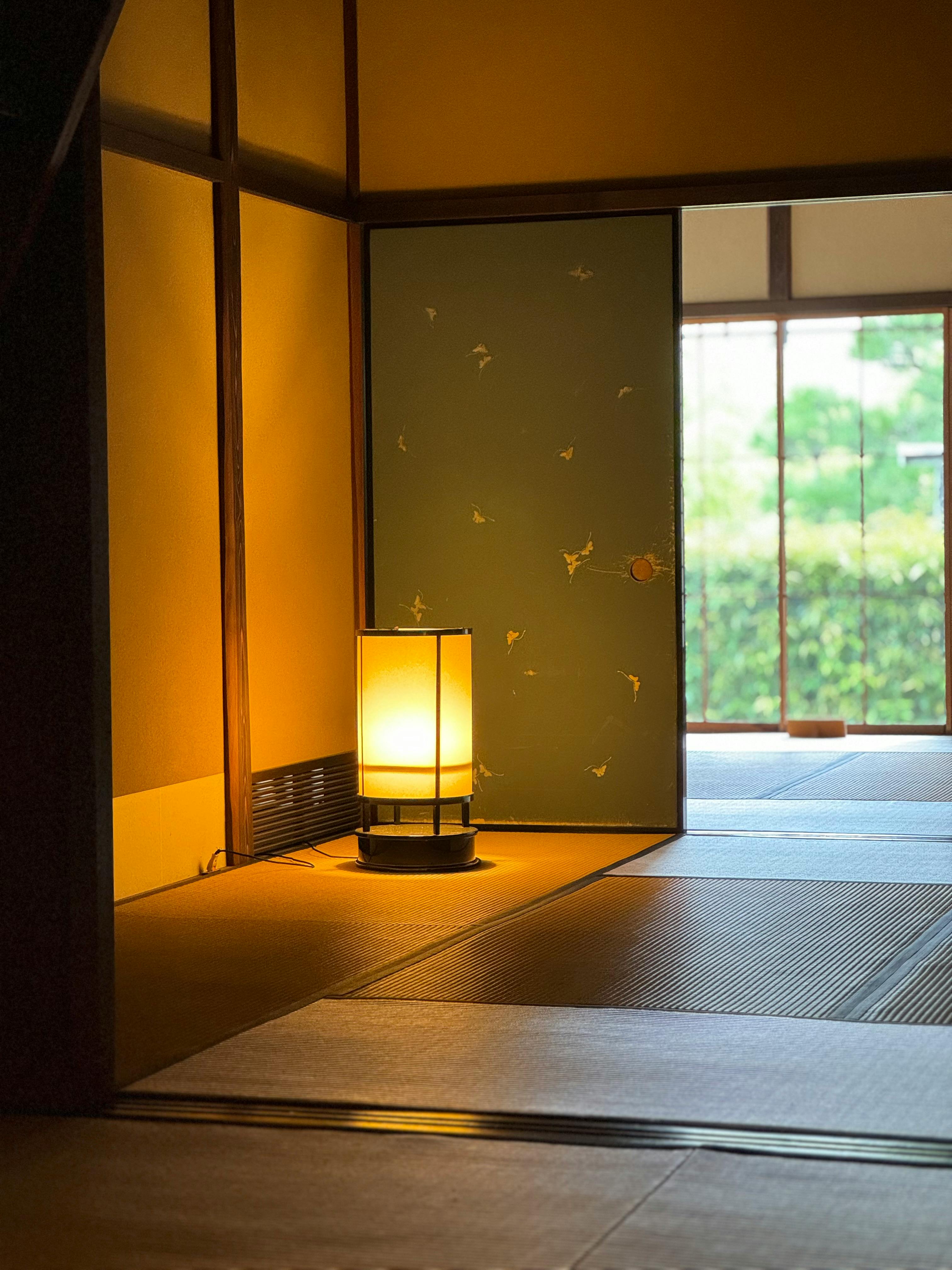 Traditional Japanese room with tatami flooring, lamp, and Engawa veranda.