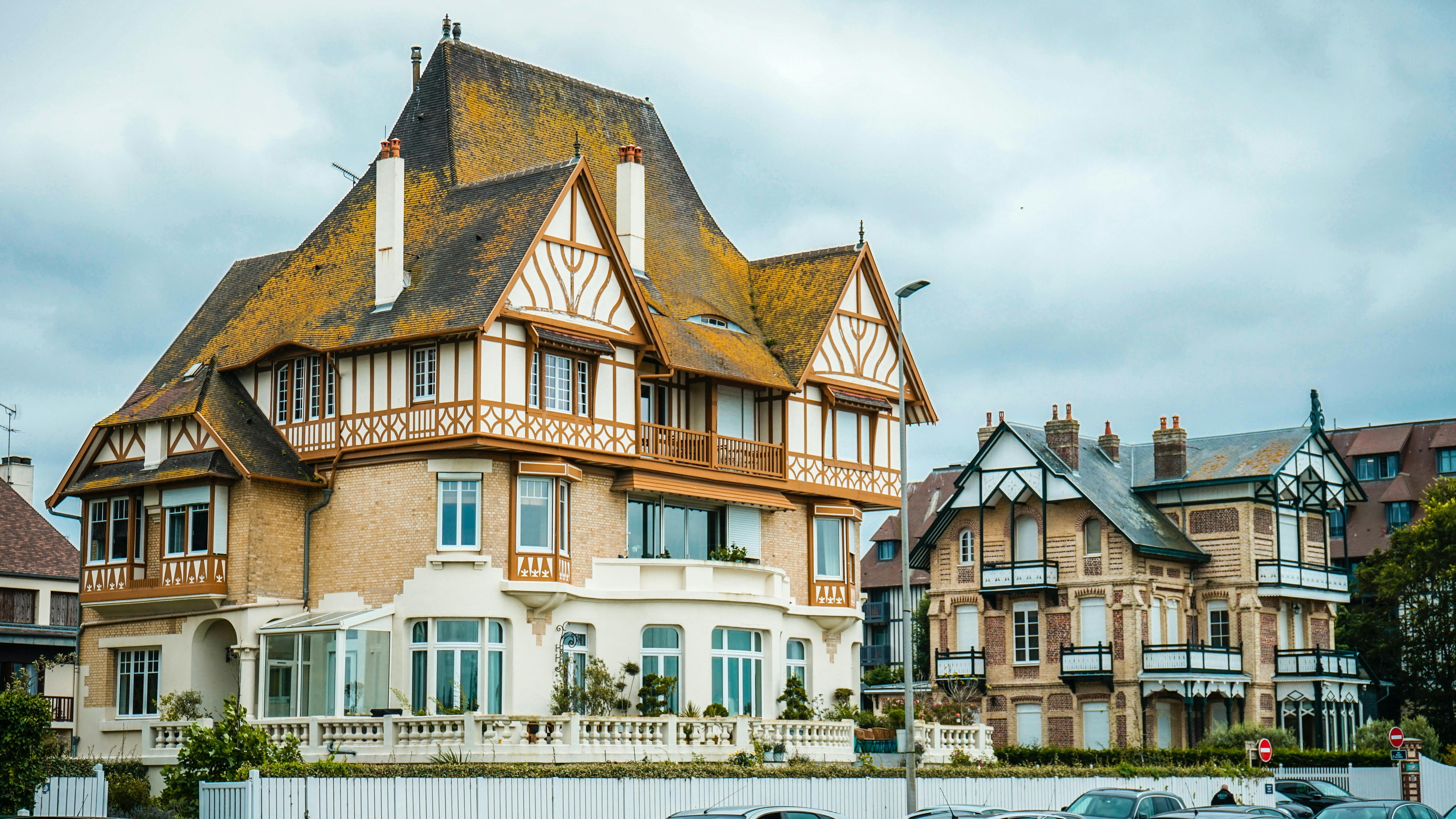 Front view of a traditional Tudor-style house with steep gables and timber framing.