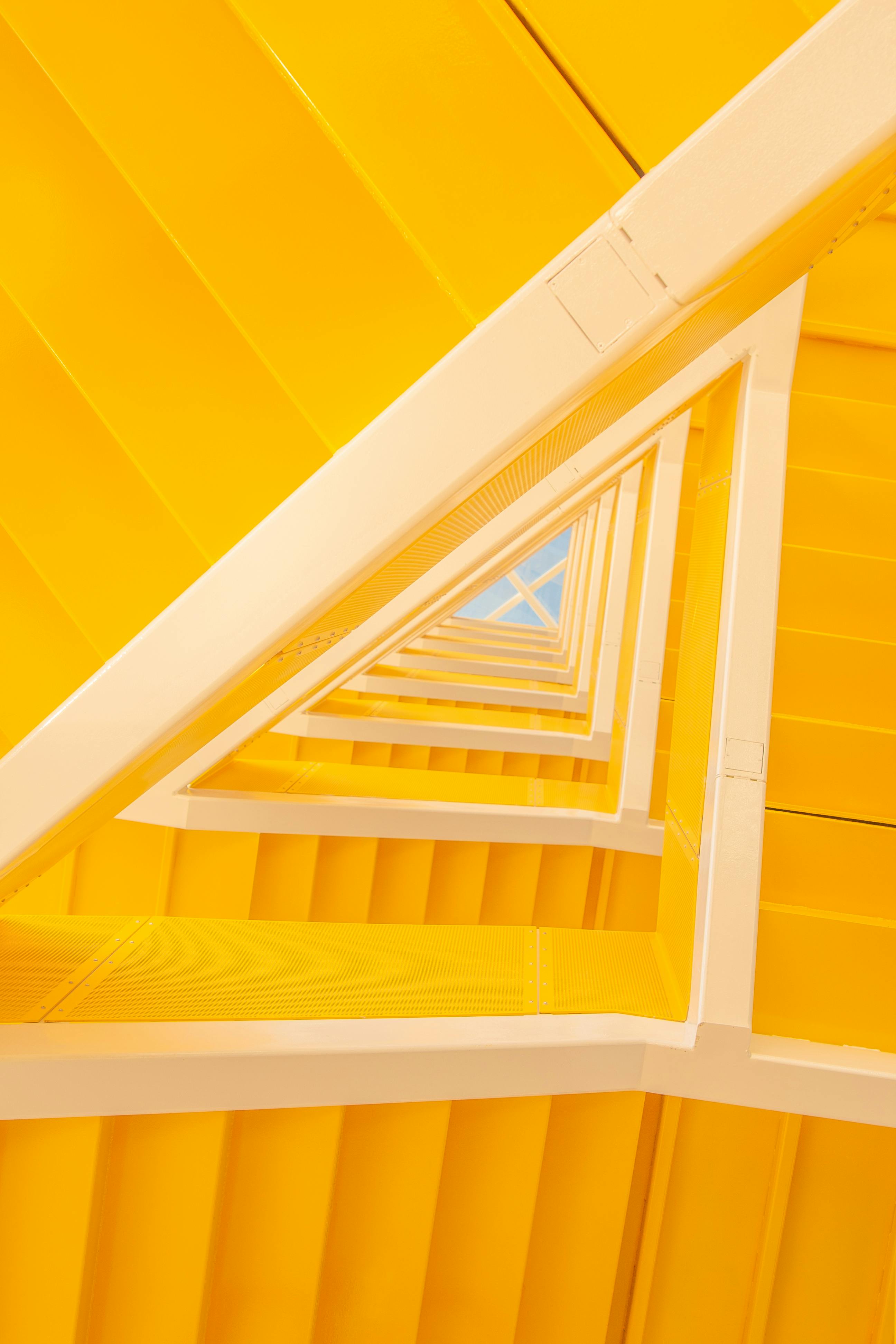 Modern interior with yellow stairway, using vibrant color to uplift mood and energize the space.