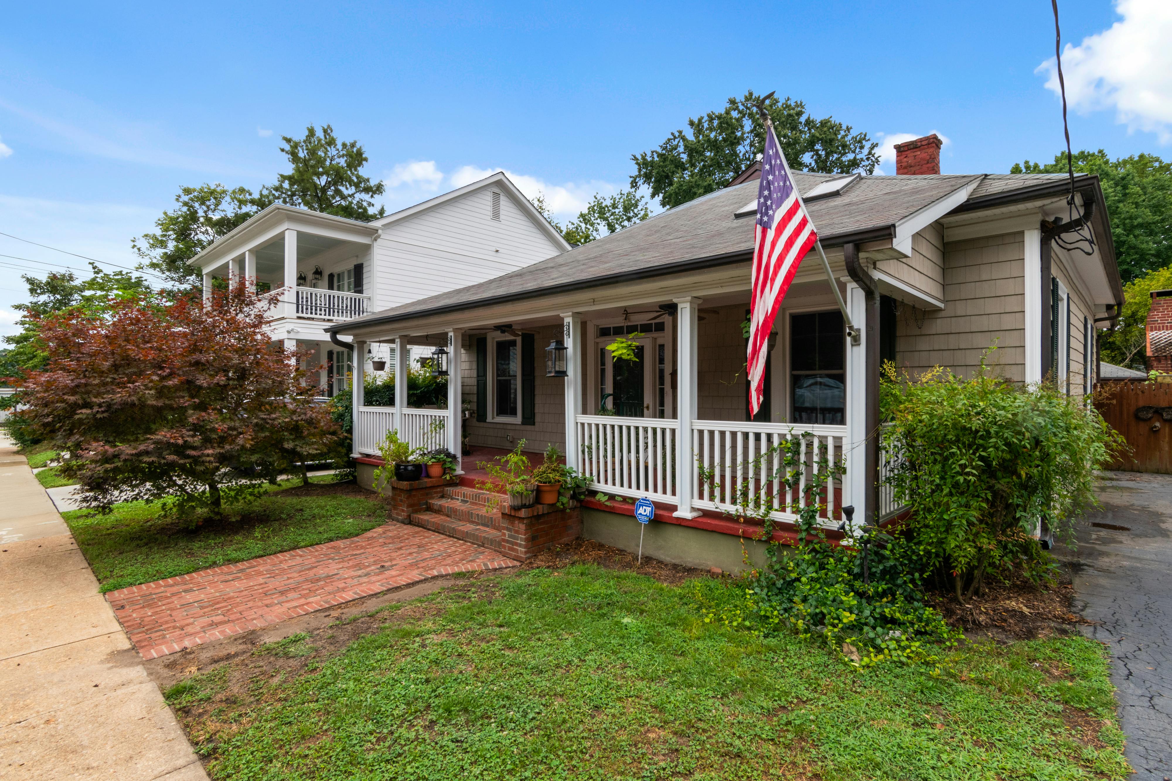 Bungalow house with American flag on porch.