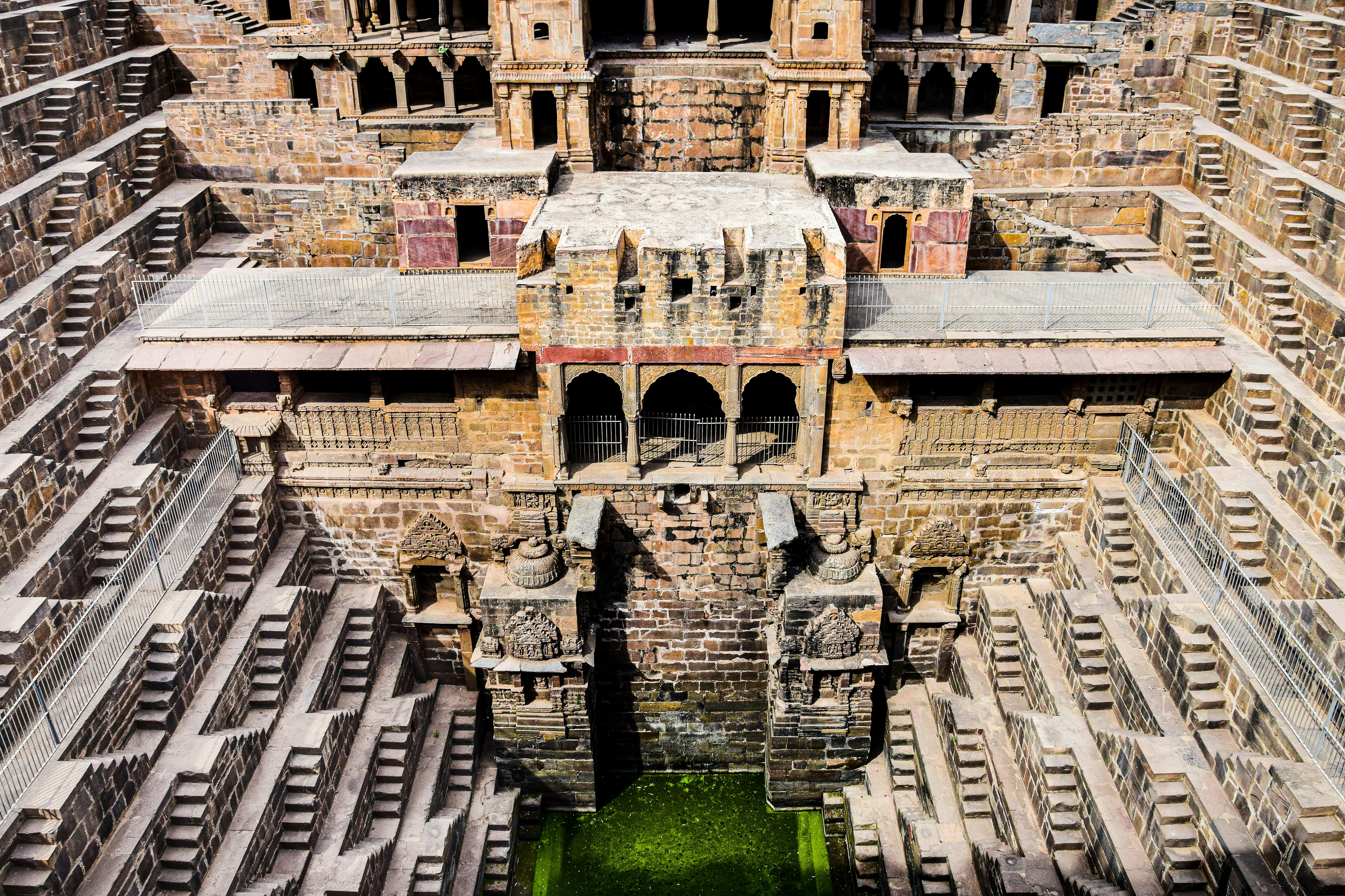 Symmetrical view of an ancient Indian stepwell with descending steps and stone walls.