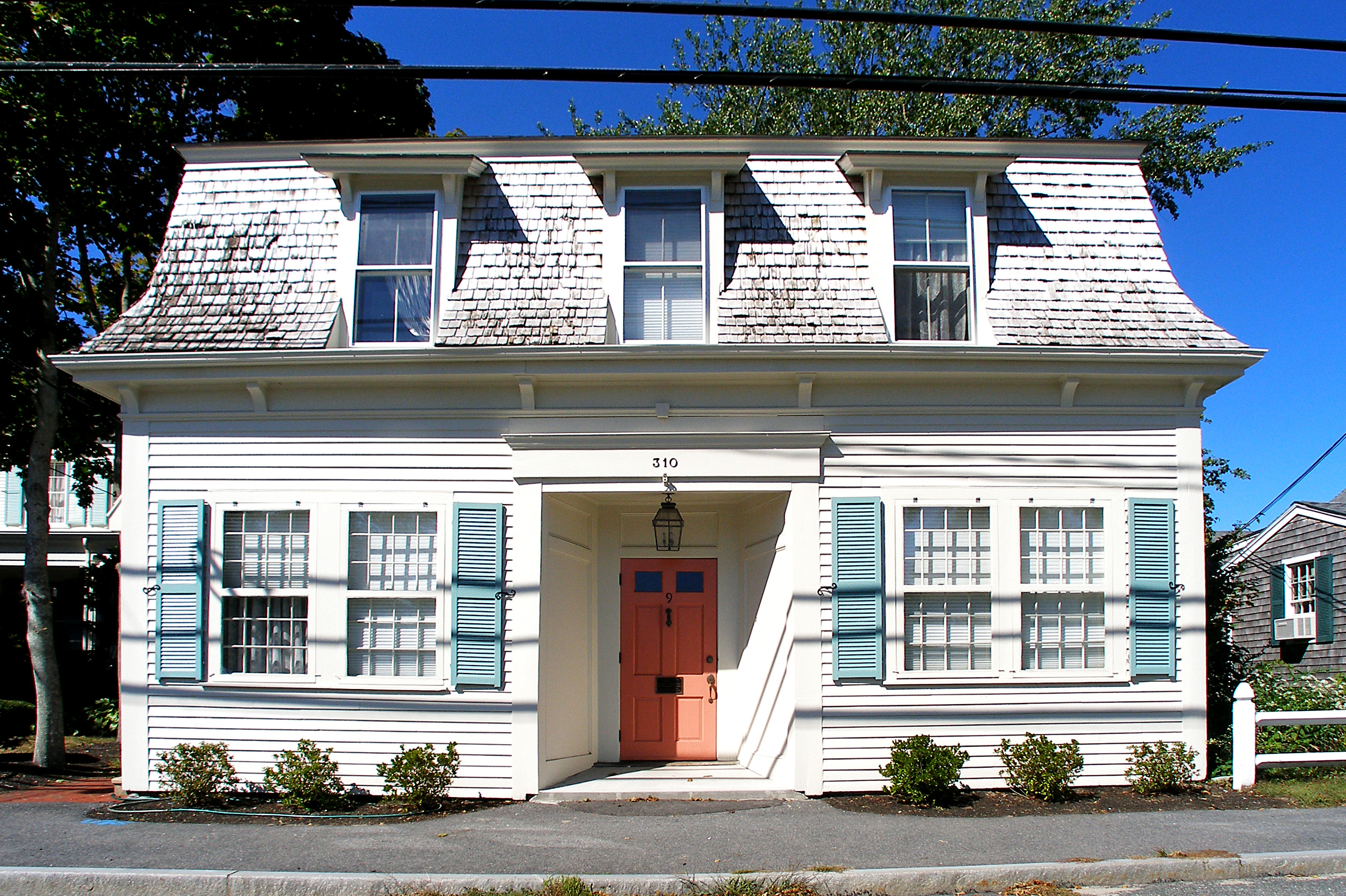 Historic Cape Cod style home with pitched roof and white clapboard.