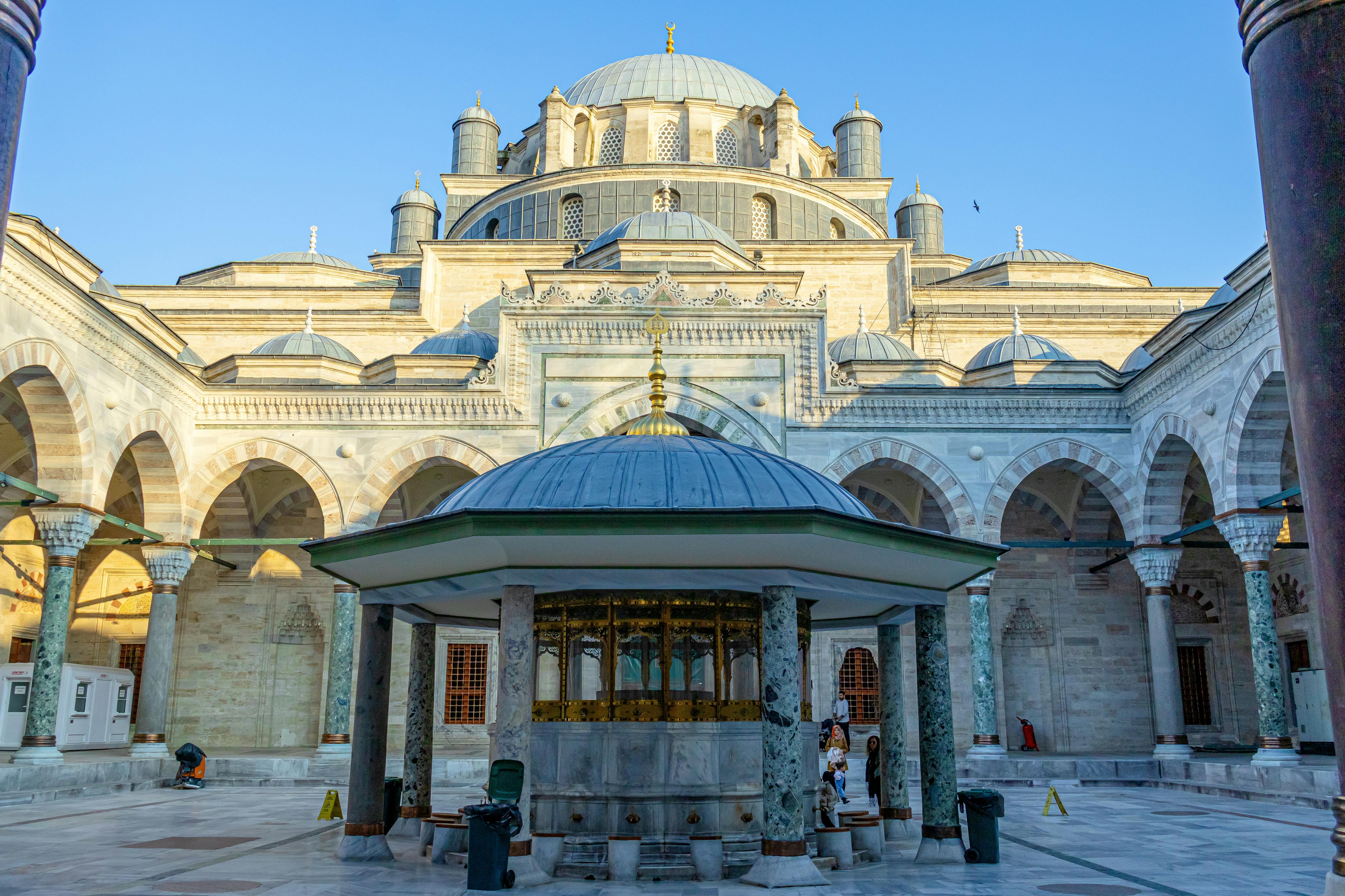 Ottoman-style courtyard at Beyazıt Mosque in Istanbul with domed arcade, central fountain, and traditional Islamic architectural detailing.