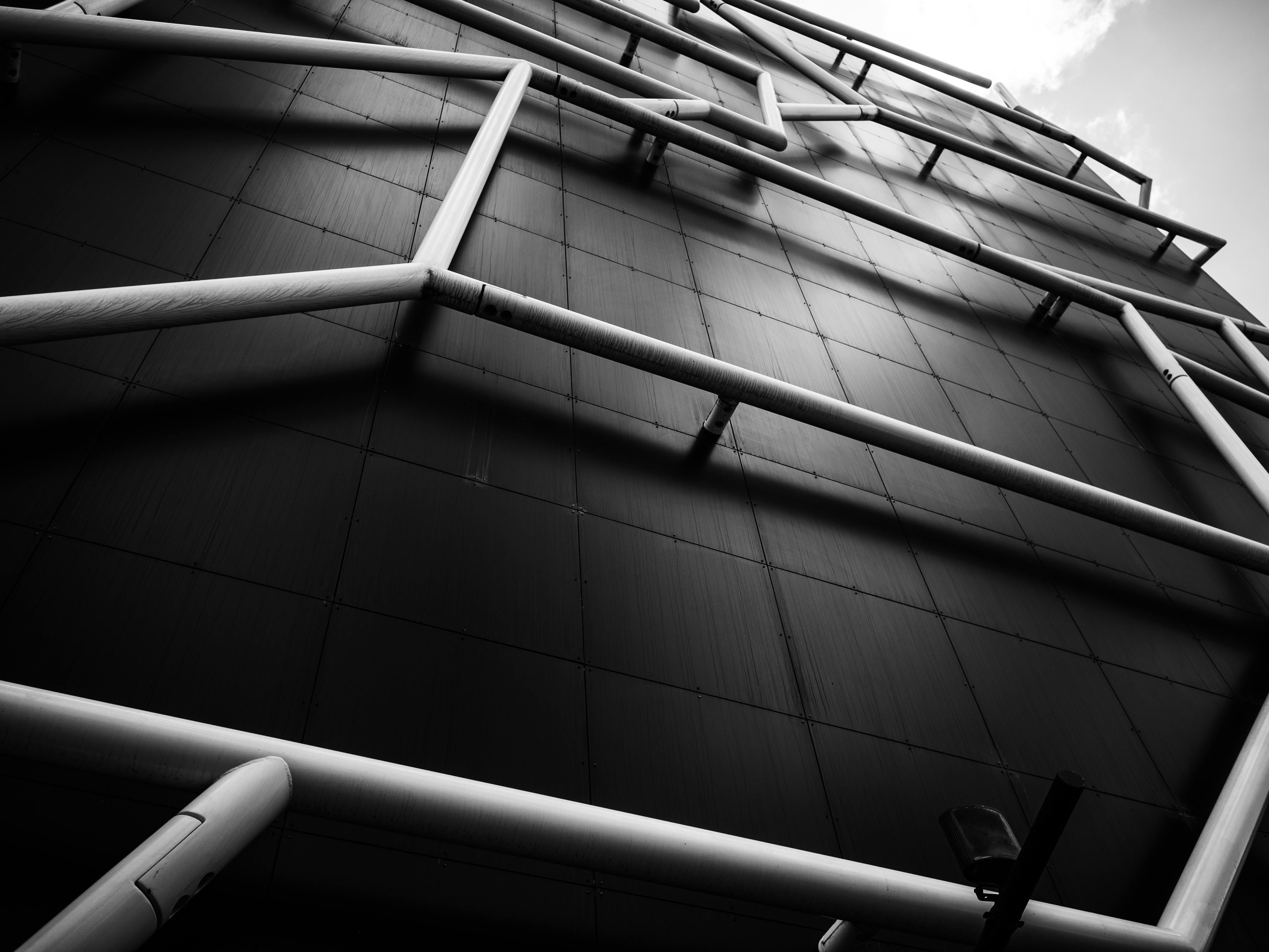 Shows exposed piping on an industrial building wall, highlighting structure and utility through architectural photography.