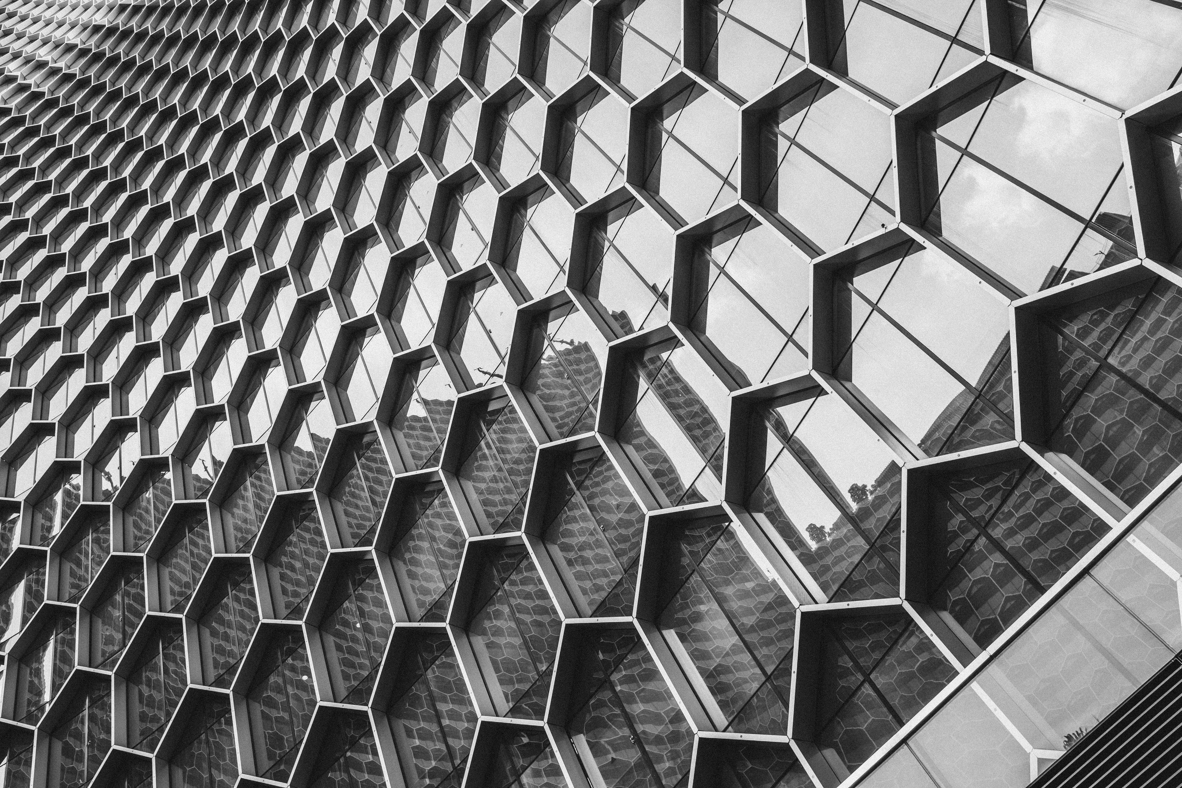 Architectural shot highlighting the sleek exterior of a contemporary glass building. Clean lines, reflective surfaces, and minimal detailing.