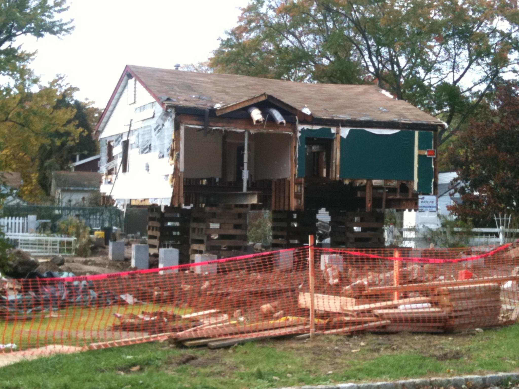 House raised on jacks during foundation lifting process.