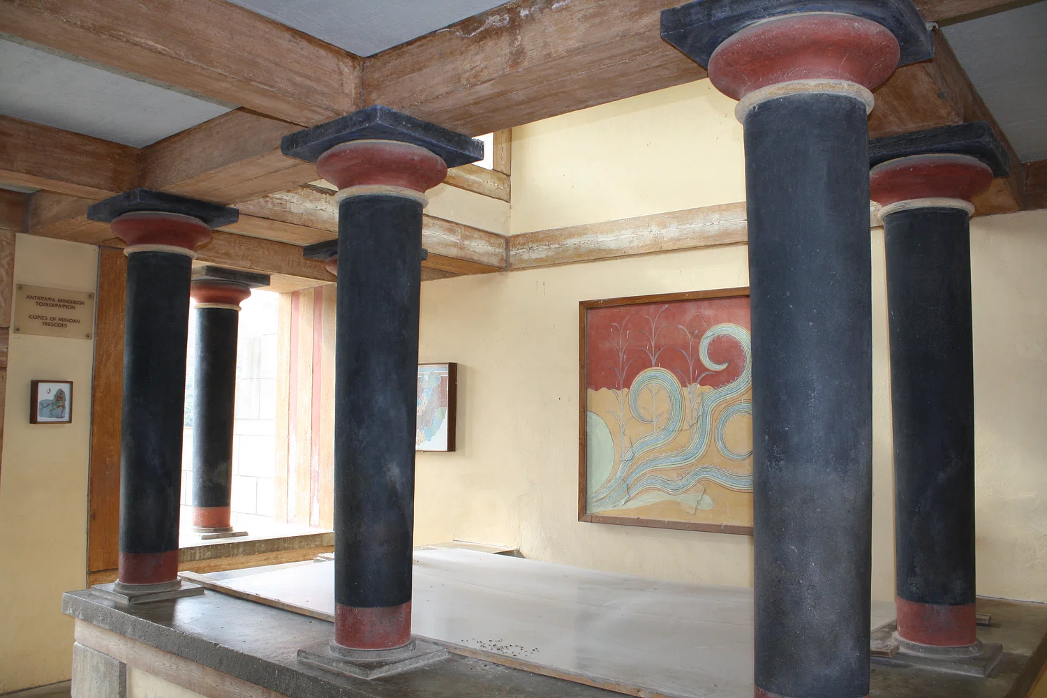 Brightly colored columns at Knossos Palace with red, black, and blue accents.