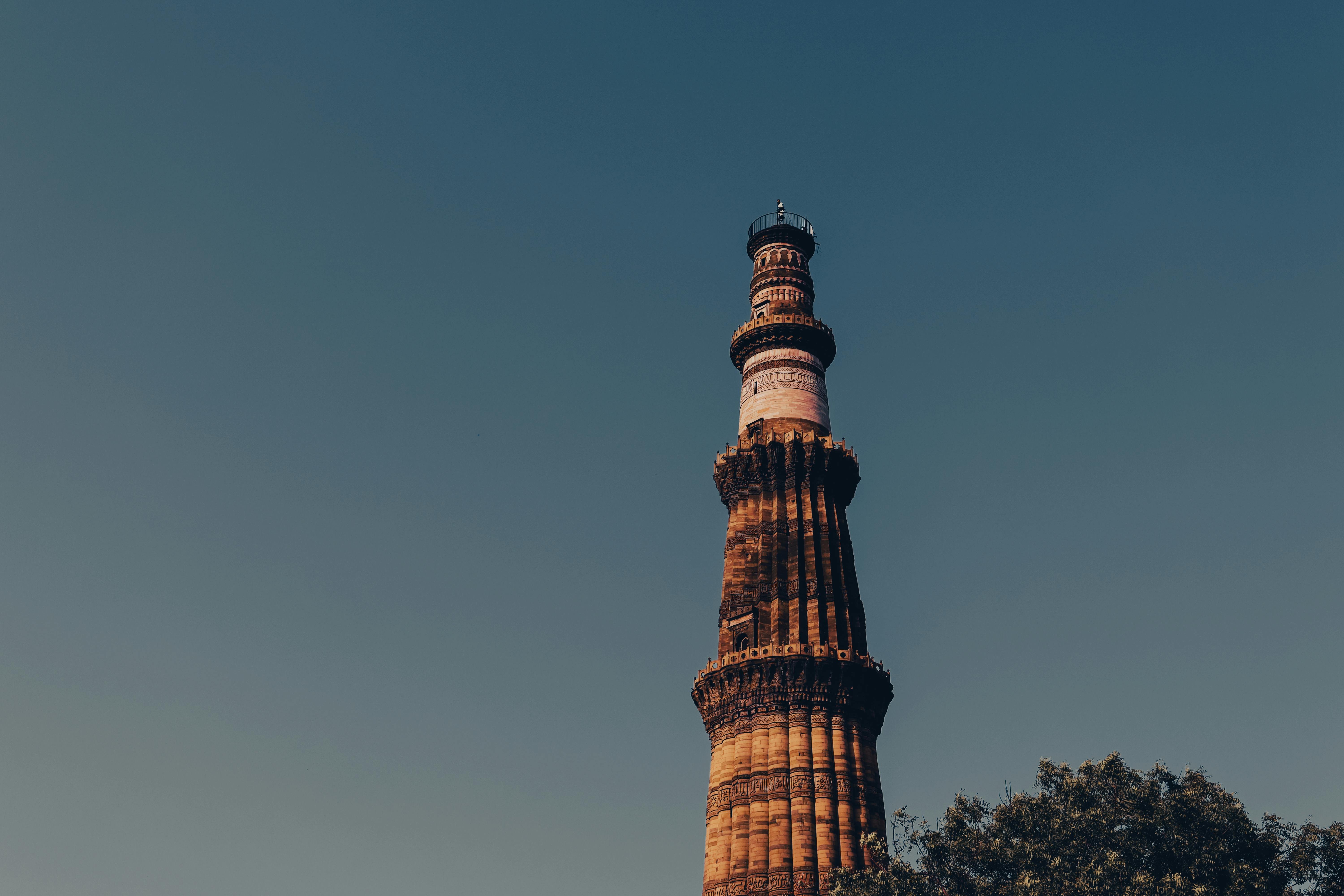 Historic Qutub Minar tower with detailed stone carvings in Delhi, India.