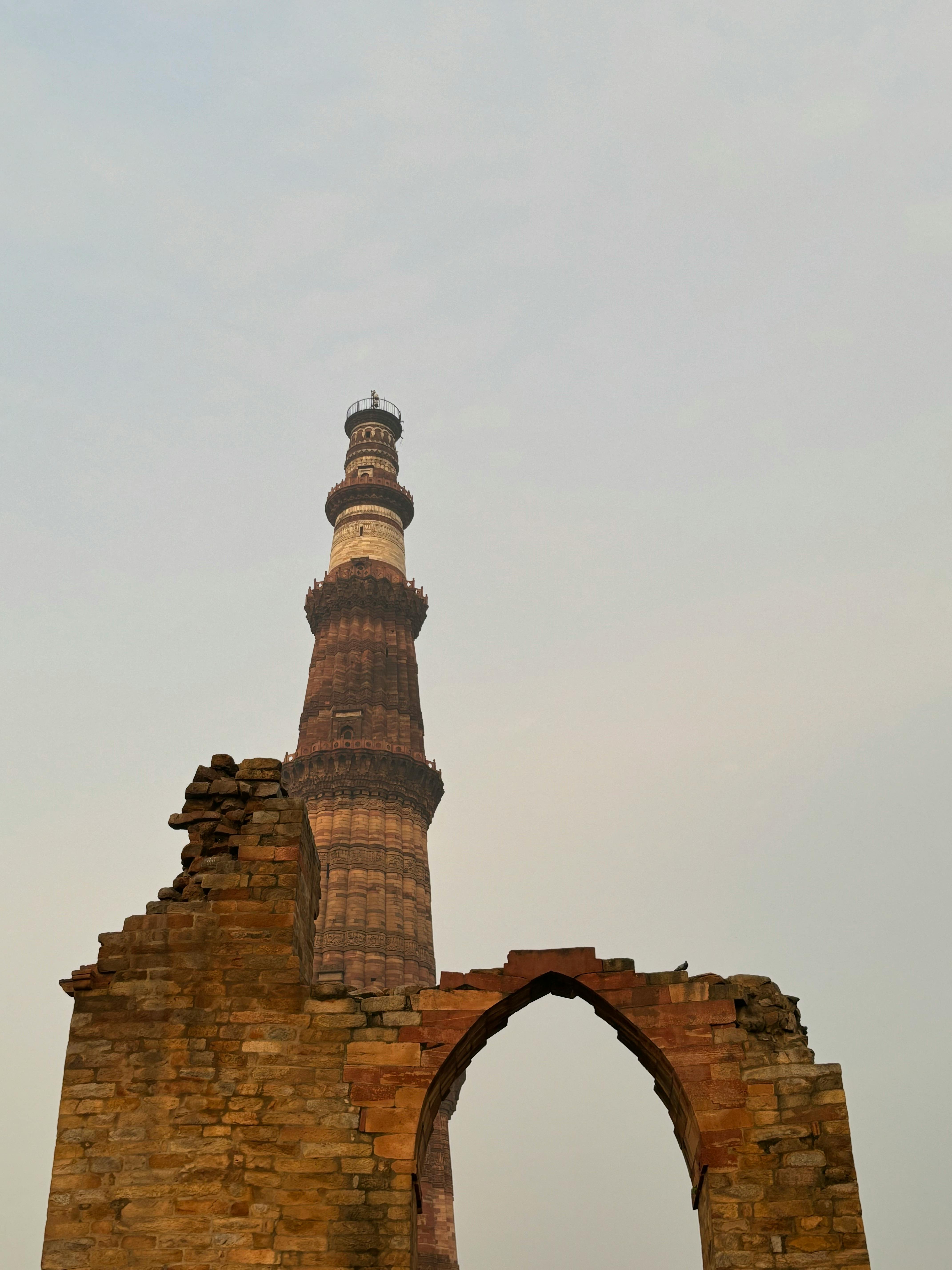Full view of Qutub Minar against a blue sky.