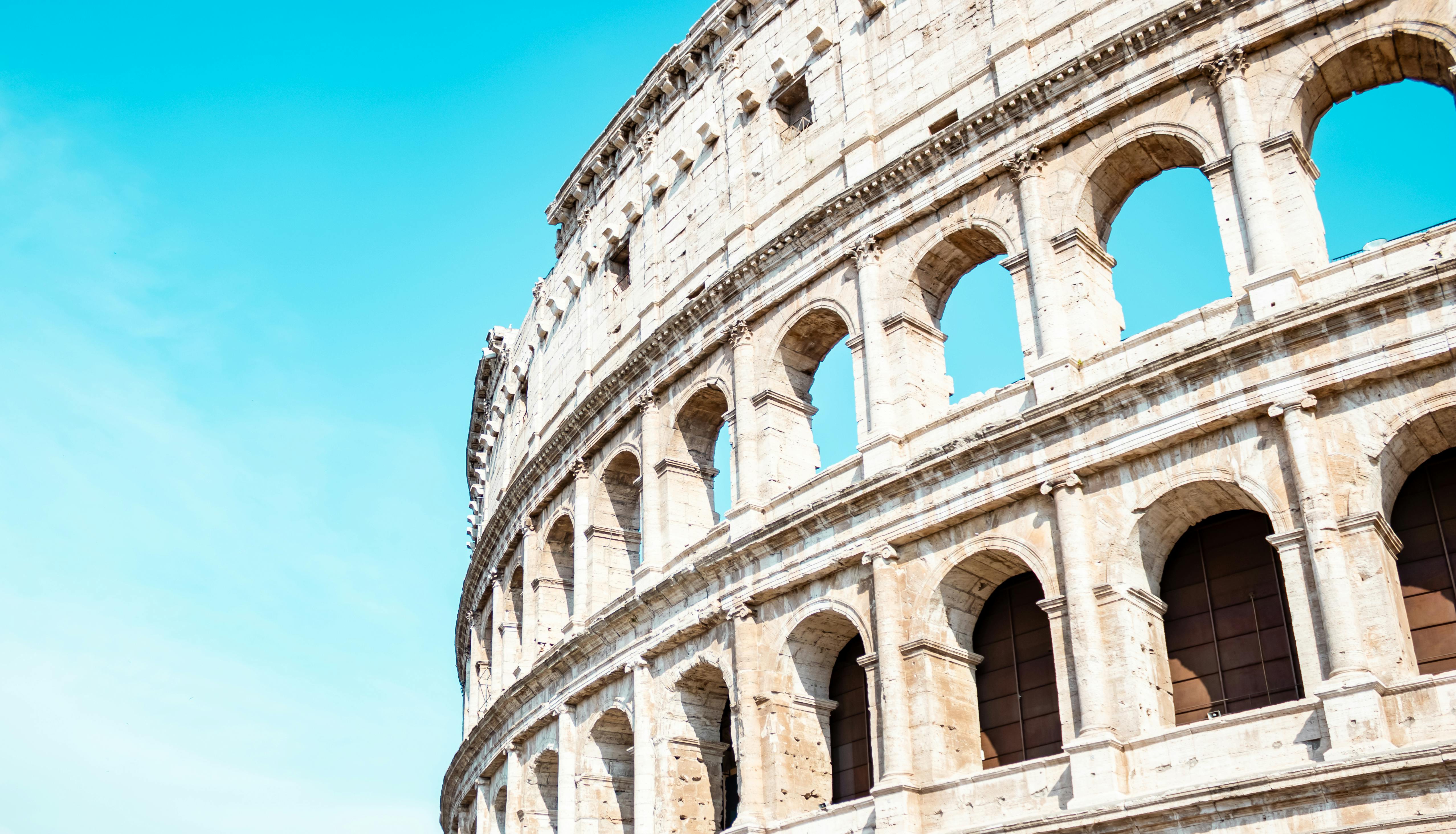 Exterior view of the Colosseum in Rome showing arches and classical structure.