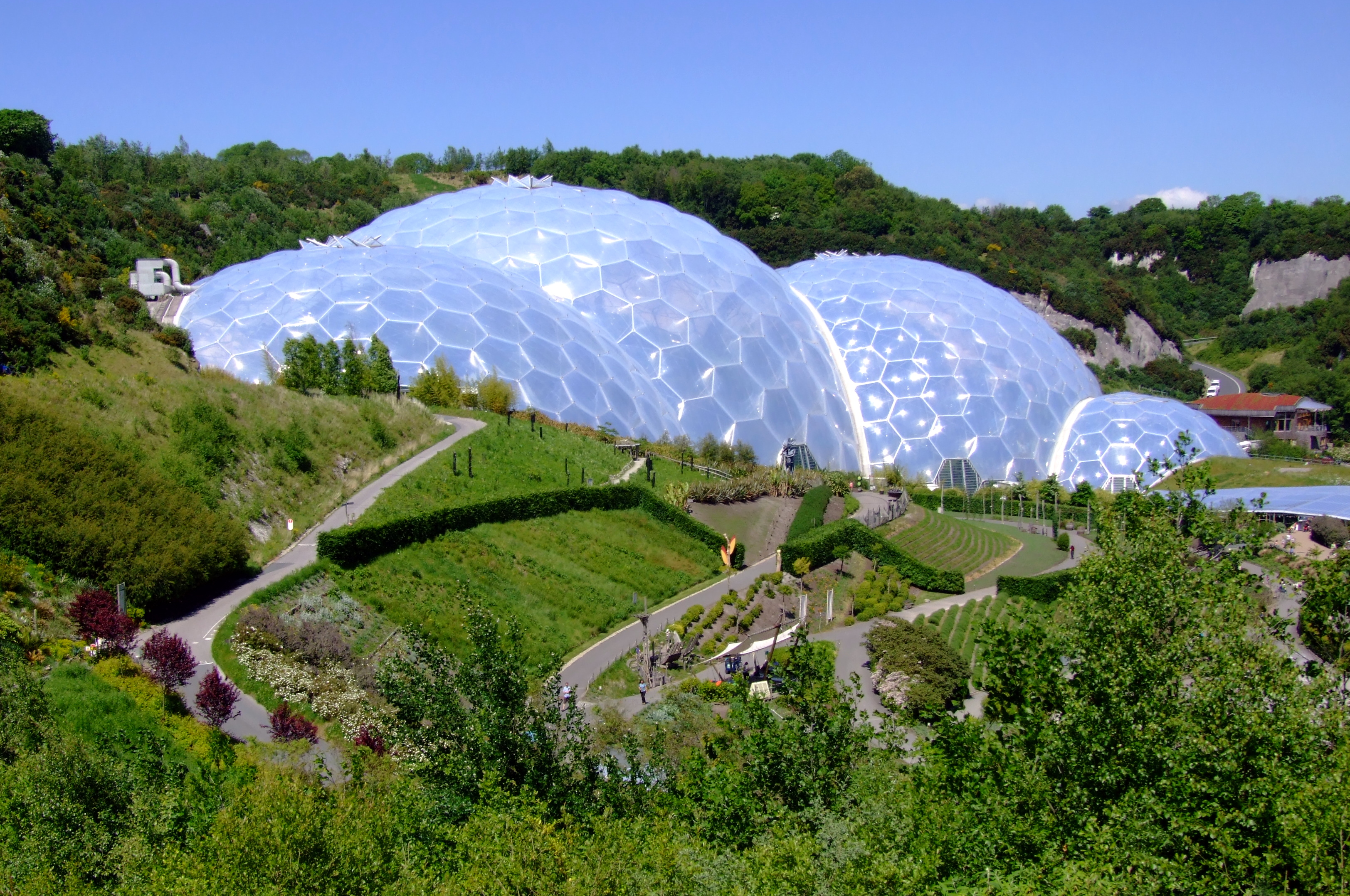 Eden Project in Cornwall with large geodesic biodomes nestled in natural landscape.