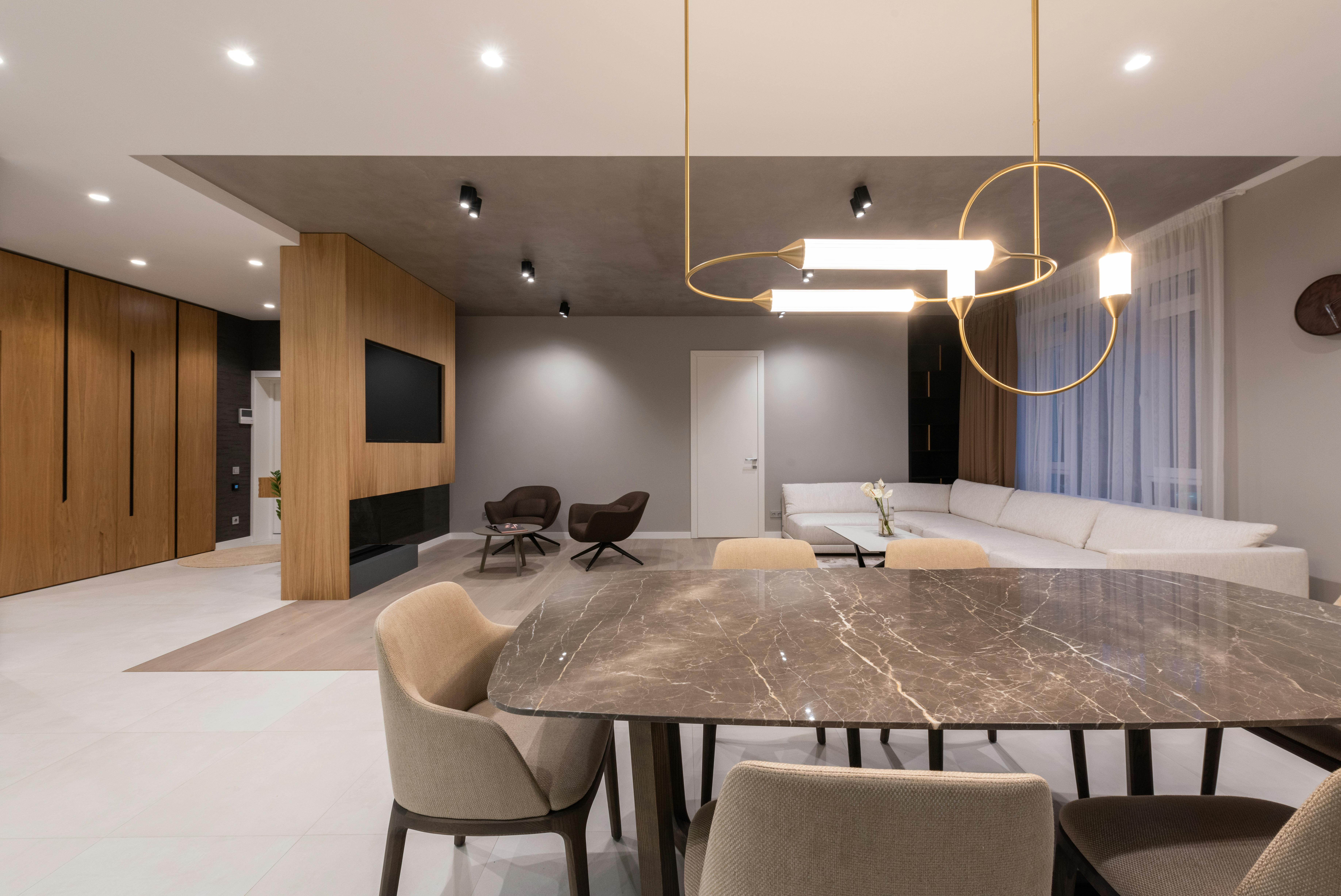 Luxury living and dining area with open layout using warm neutral tones in beige and clay shades.