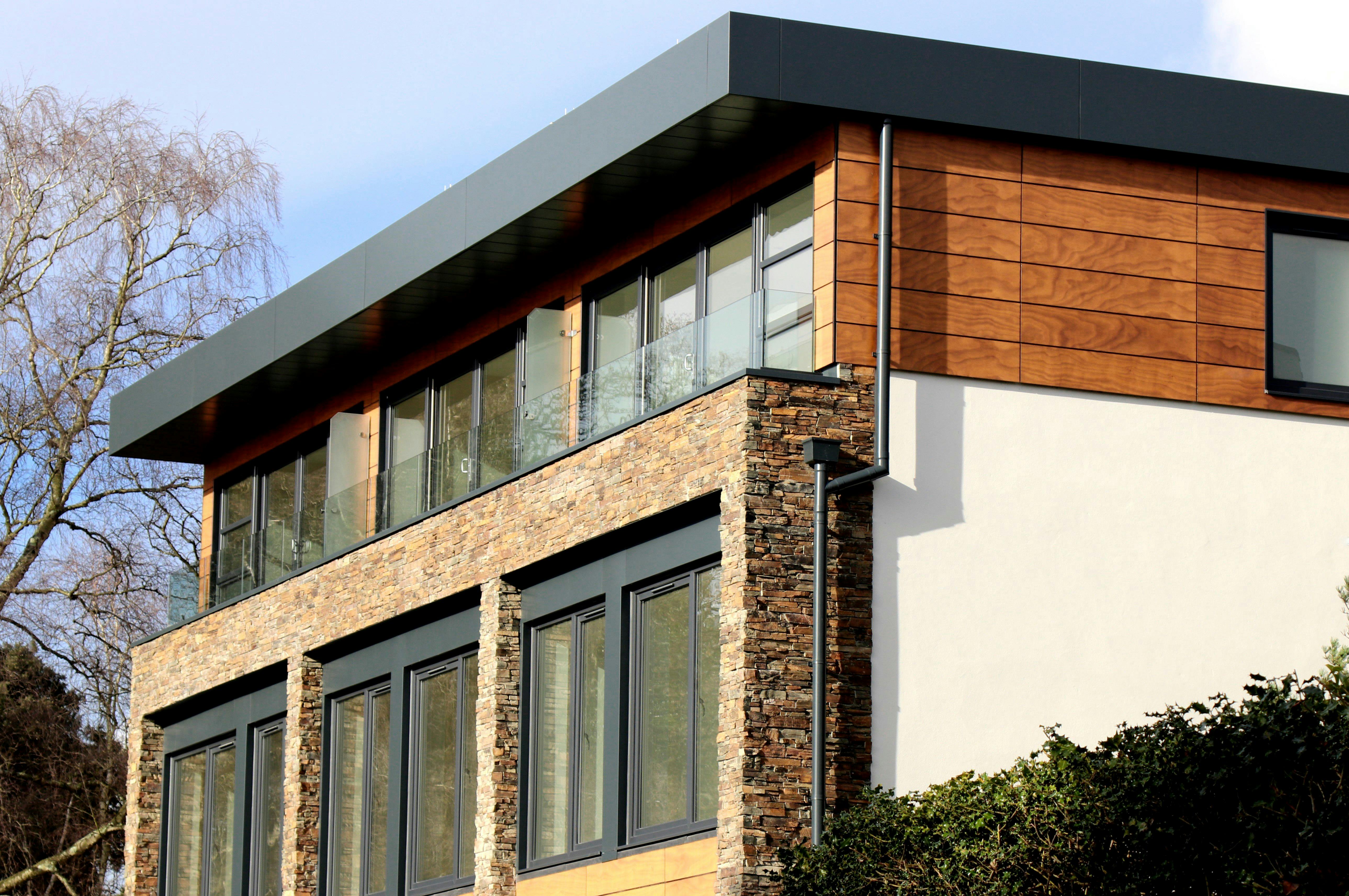 Facade of a modern stone house highlighting clean lines and natural materials.