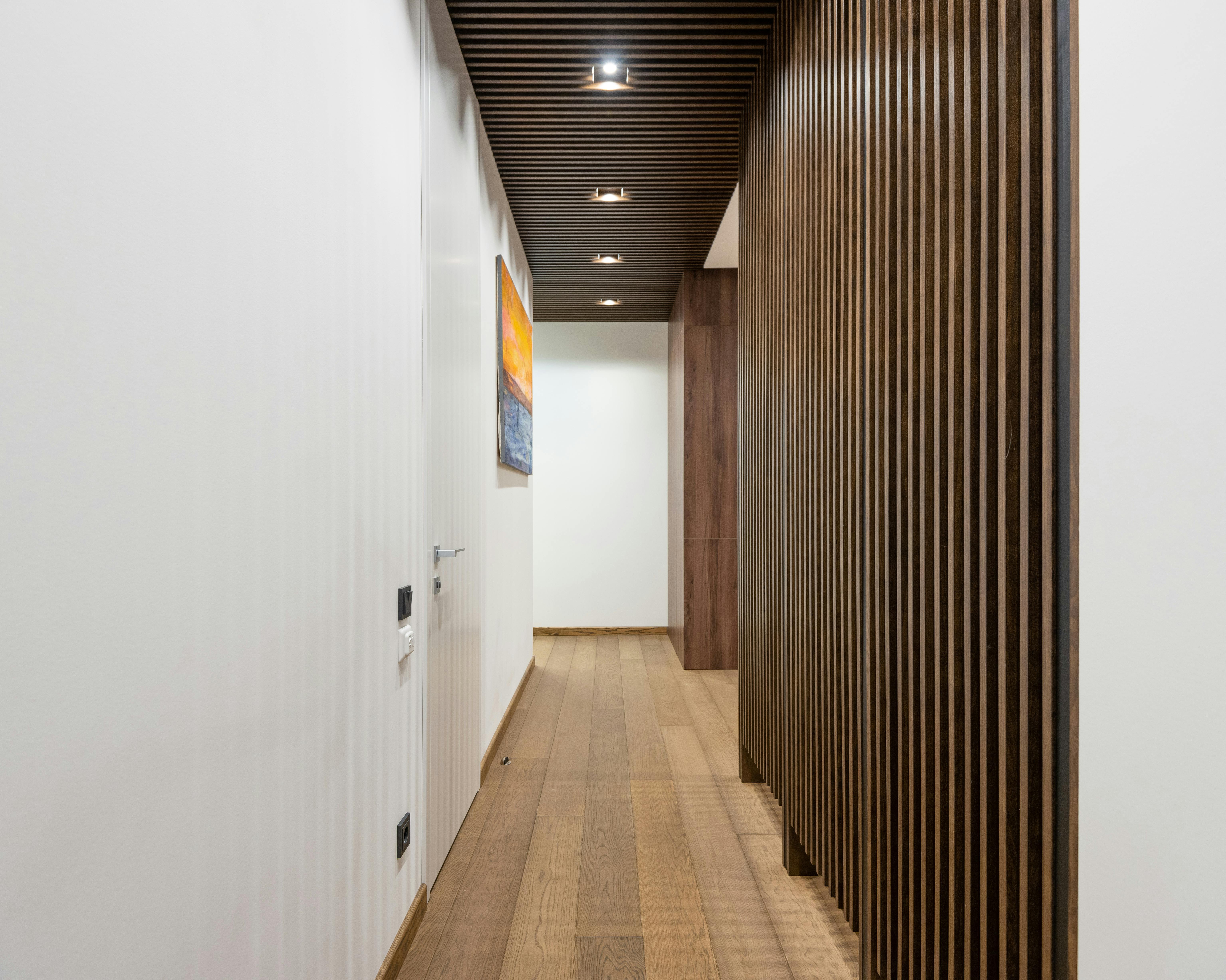 Narrow corridor with wooden partitions and a cohesive neutral color palette.