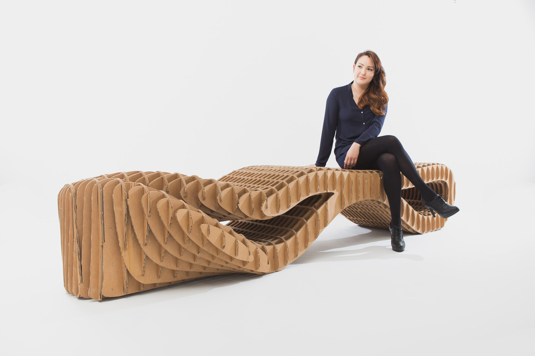 Sculptural cardboard bench with flowing parametric curves.