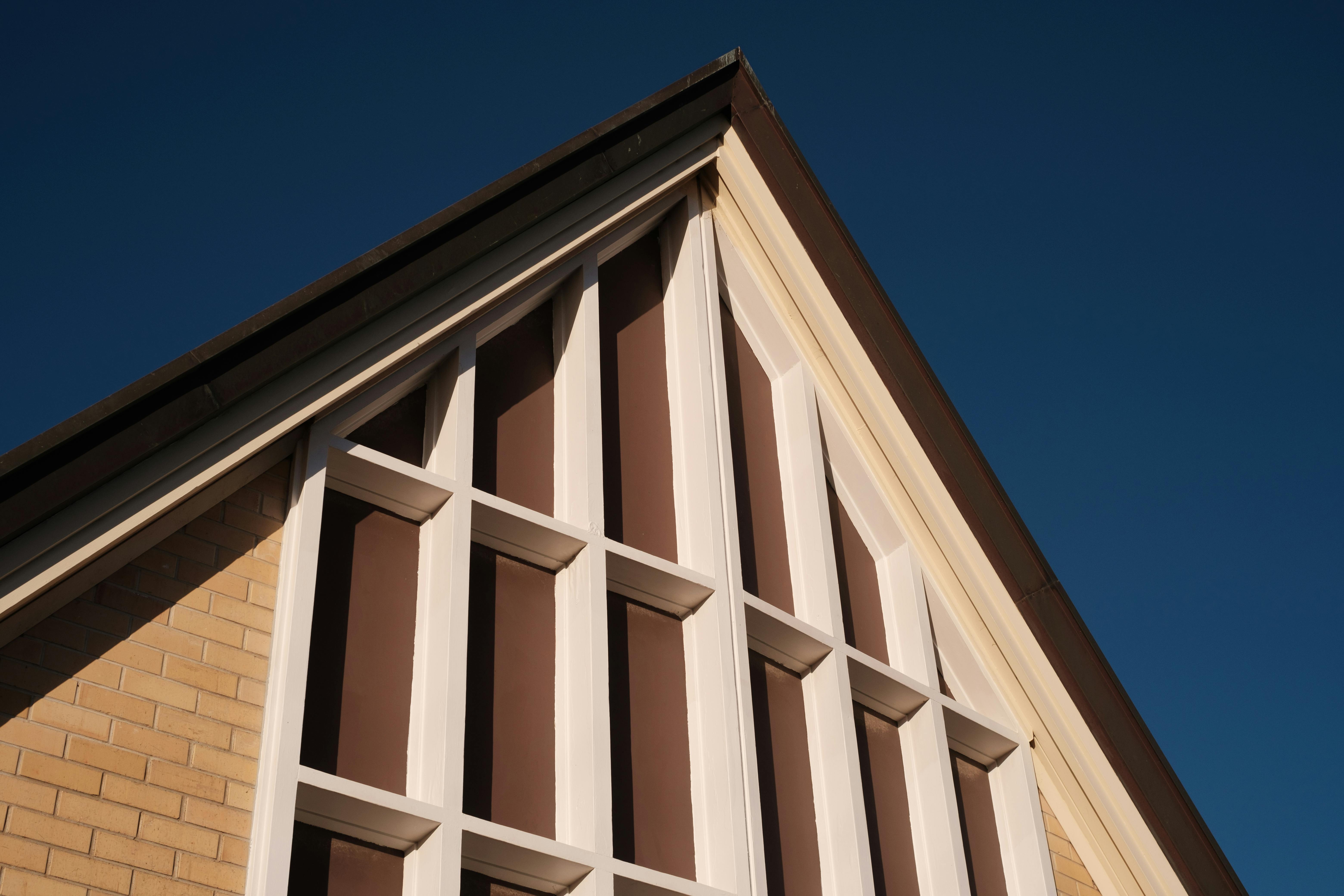Simple facade with triangular roof and minimal detailing.