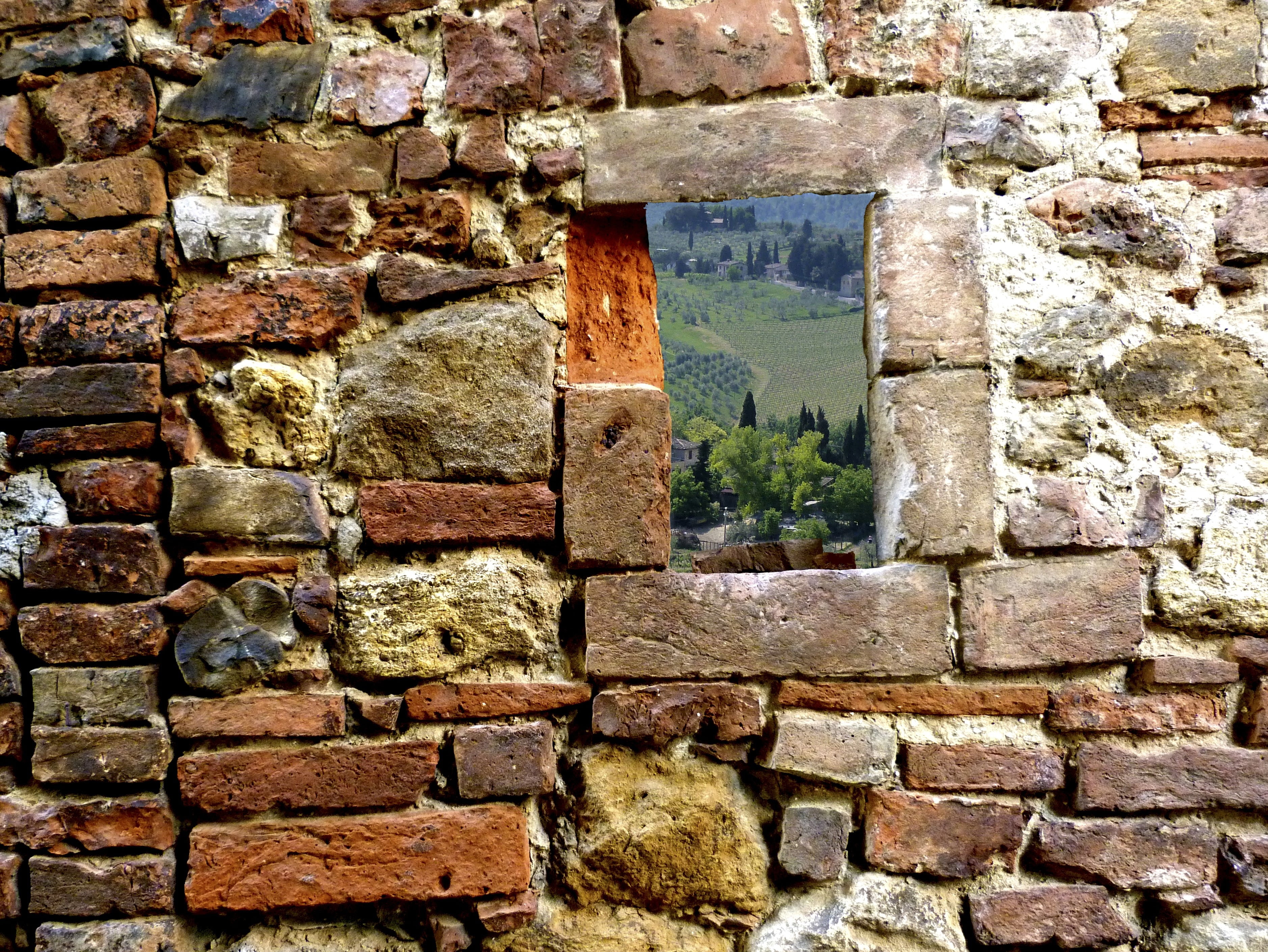Stone structure forming a window-like opening that frames surrounding greenery.