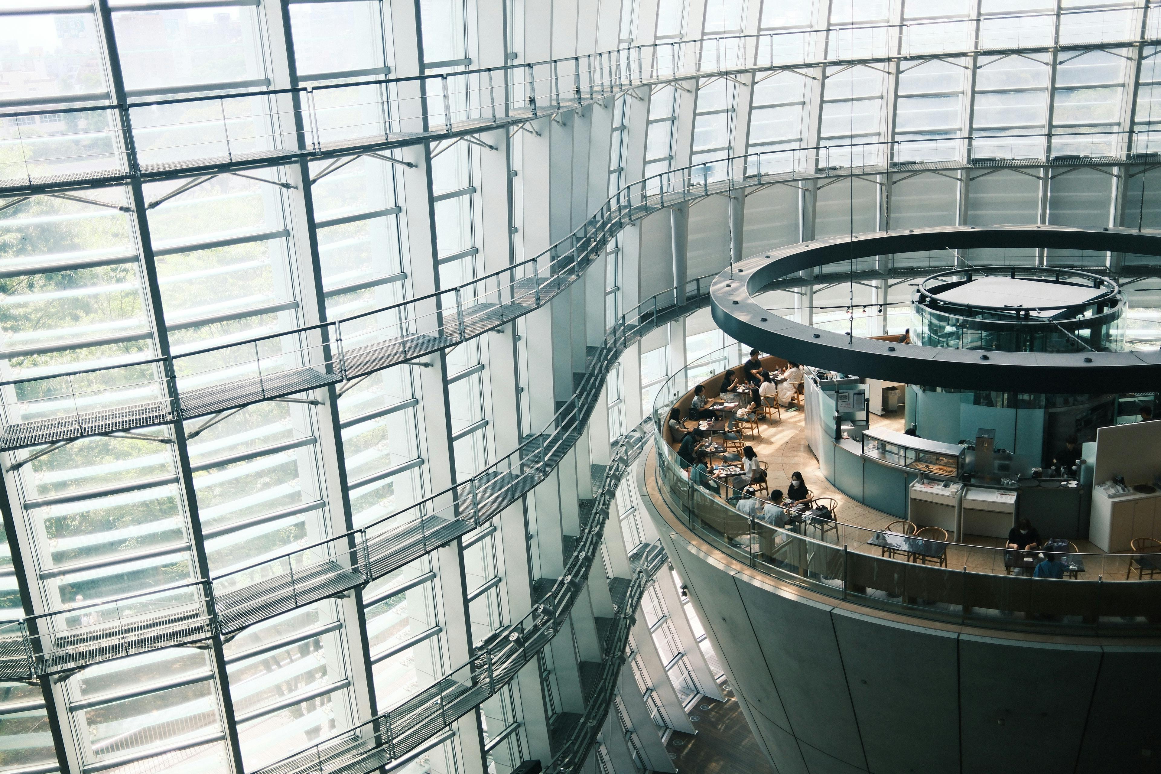 Contemporary human-centered architecture in Tokyo featuring a glass façade that brings in natural light and rounded interior spaces designed to encourage easier interaction among workers.