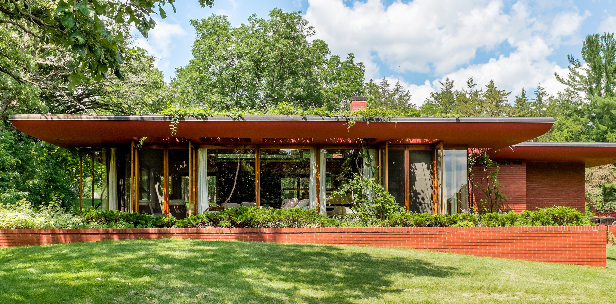Restored Usonian home with flat roof, clerestory windows, and natural wood interiors.