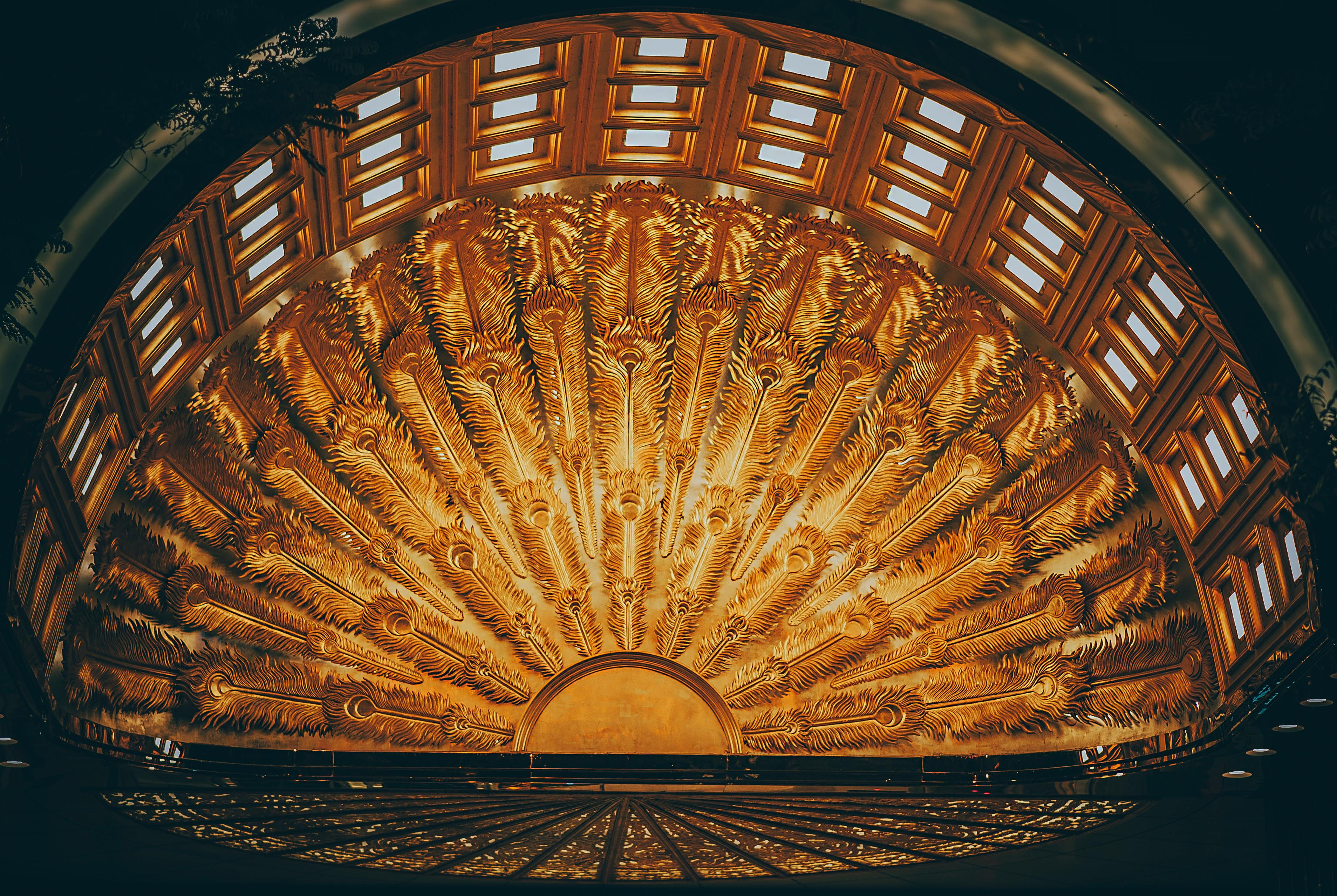 Ornate golden ceiling with radiating feather-like patterns.