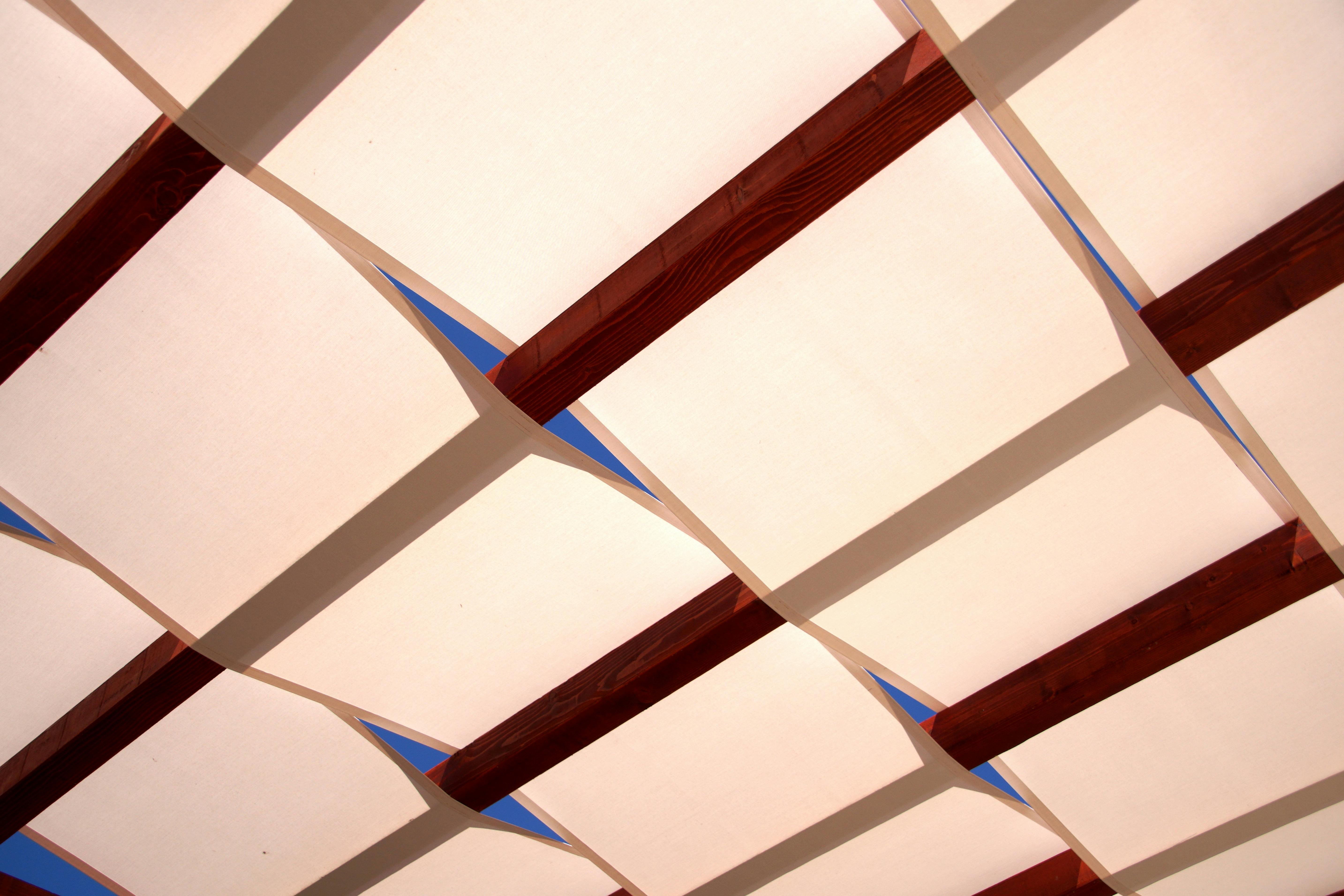 Outdoor fabric canopy with wooden bars in contemporary style.
