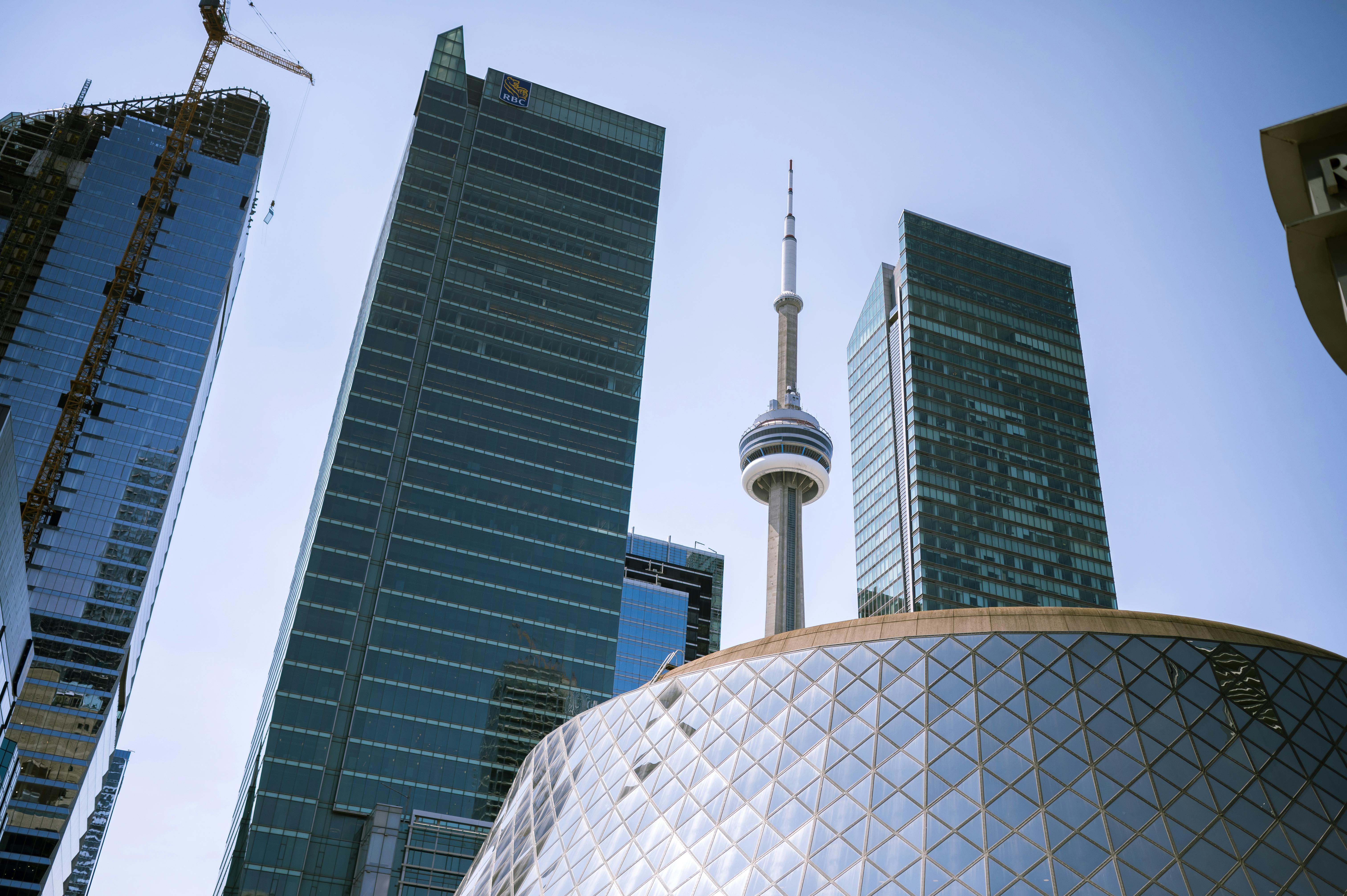 CN Tower among high-rise glass buildings under construction in Toronto.