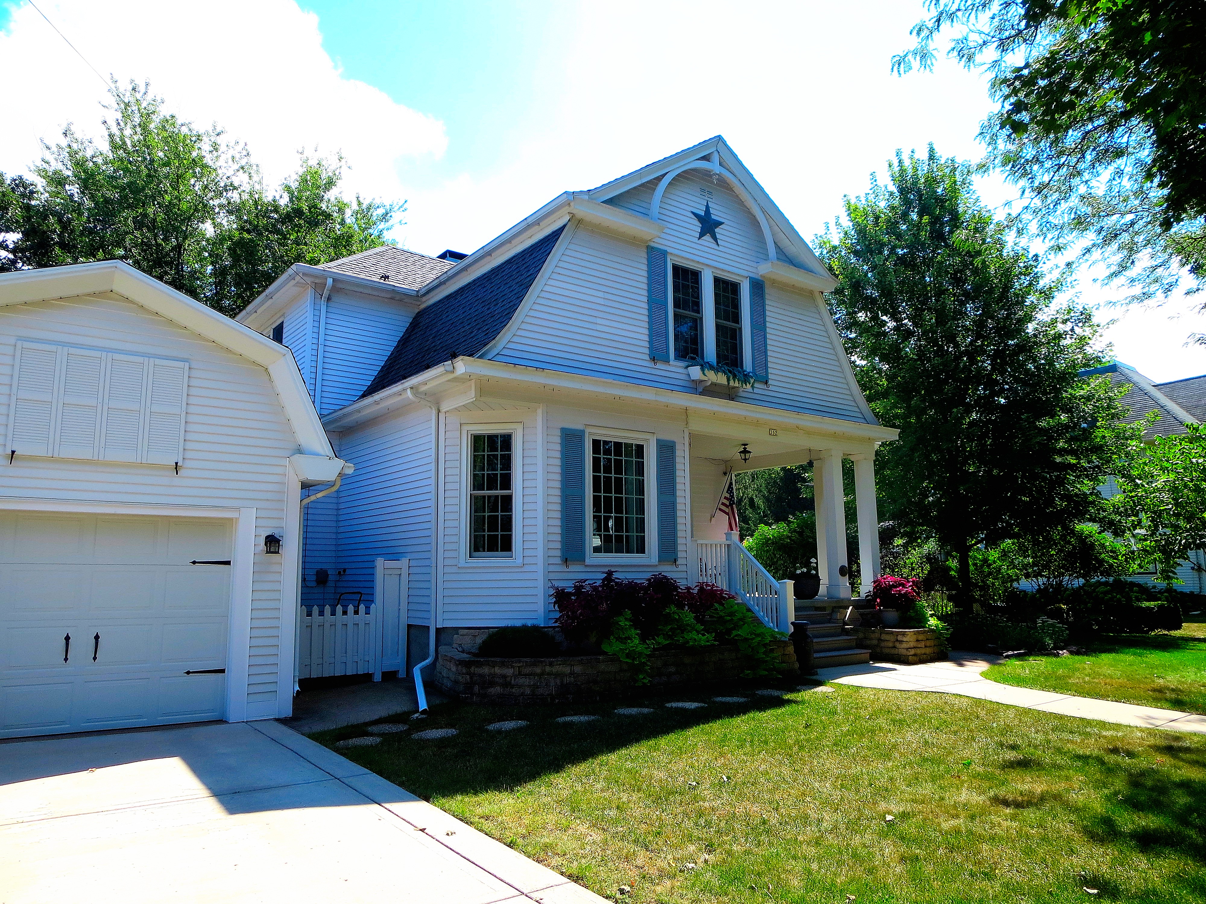 Well-kept Dutch Colonial Revival house exterior.