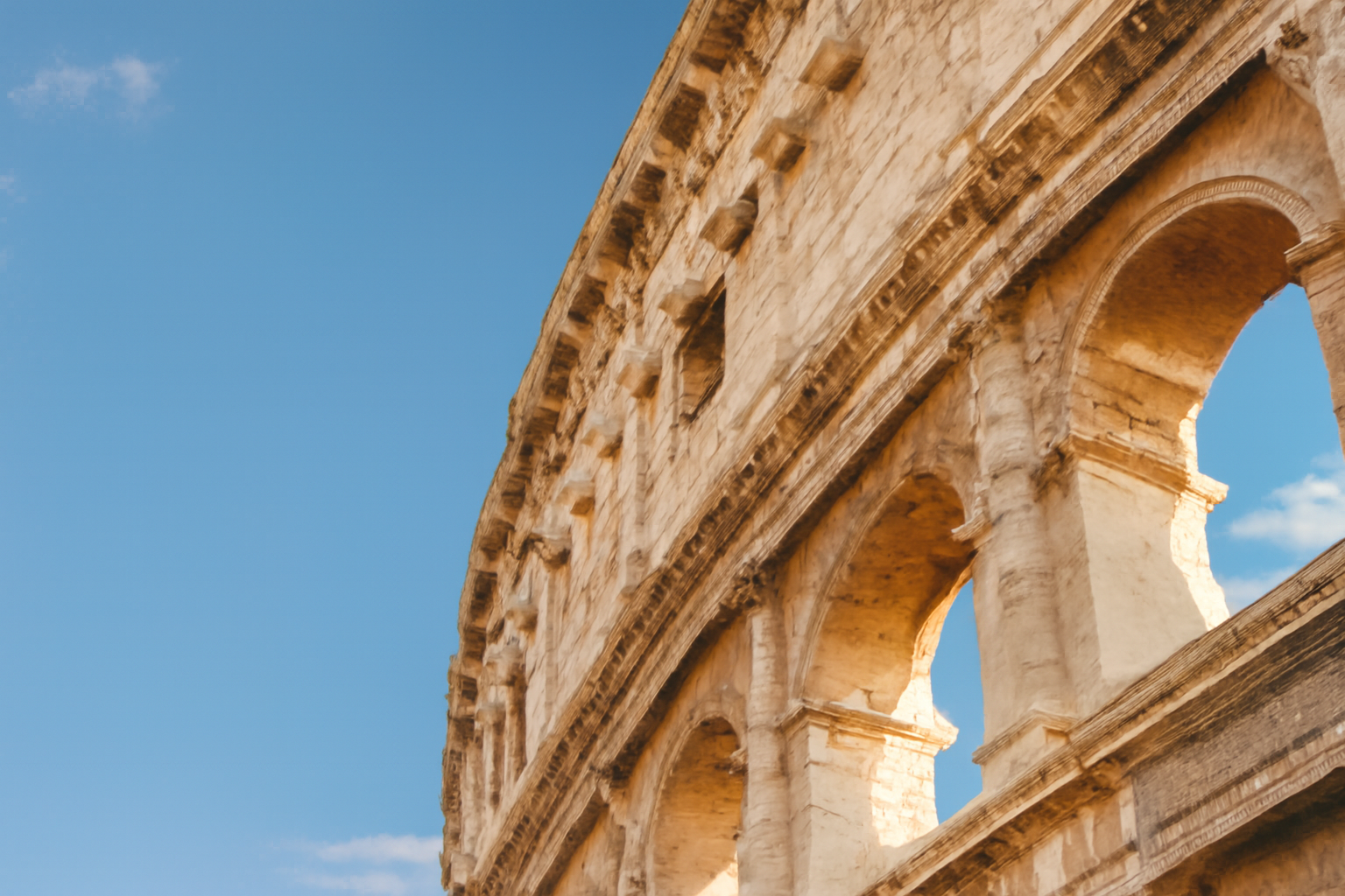 The ancient Colosseum in Rome, Italy, still standing showcasing its iconic arches and historic architecture.