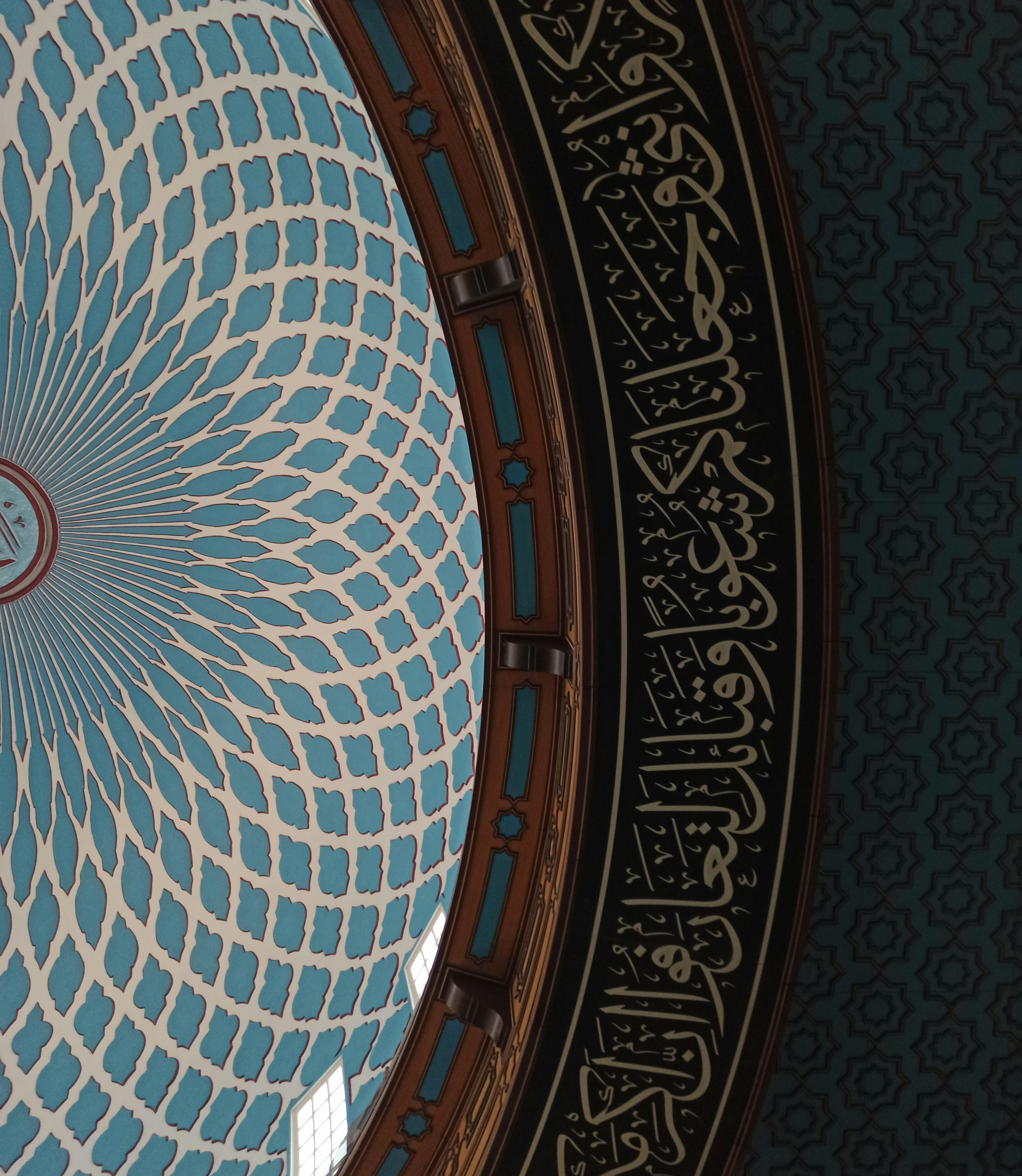 Close-up of Arabic calligraphy with Islamic geometric and arabesque patterns.
