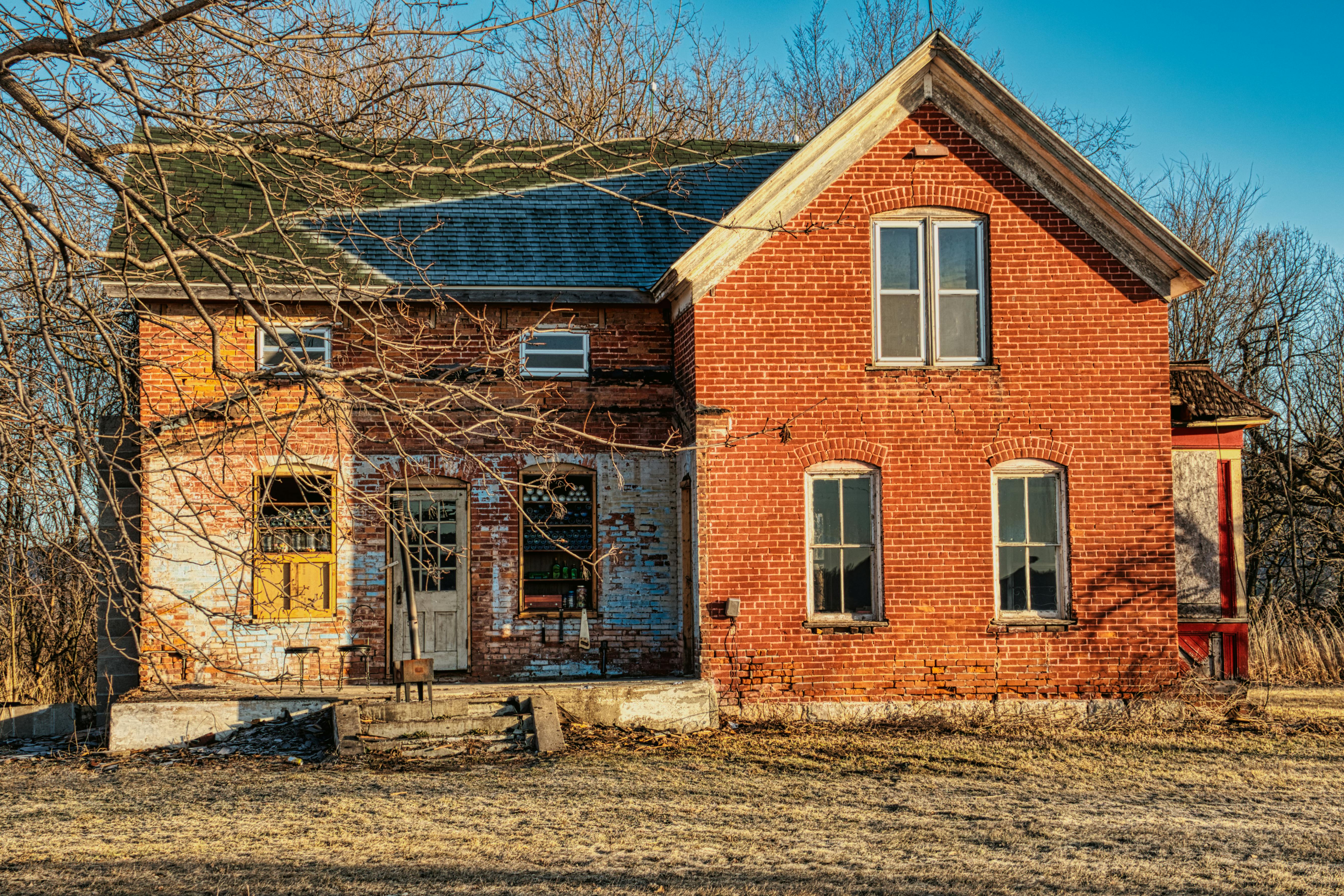 Damaged brown brick house before repair.