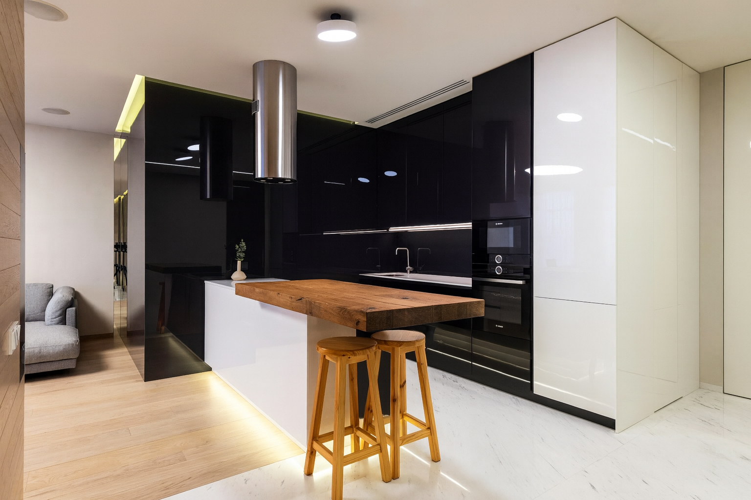 Luxurious kitchen with black cabinets and white marble counters.