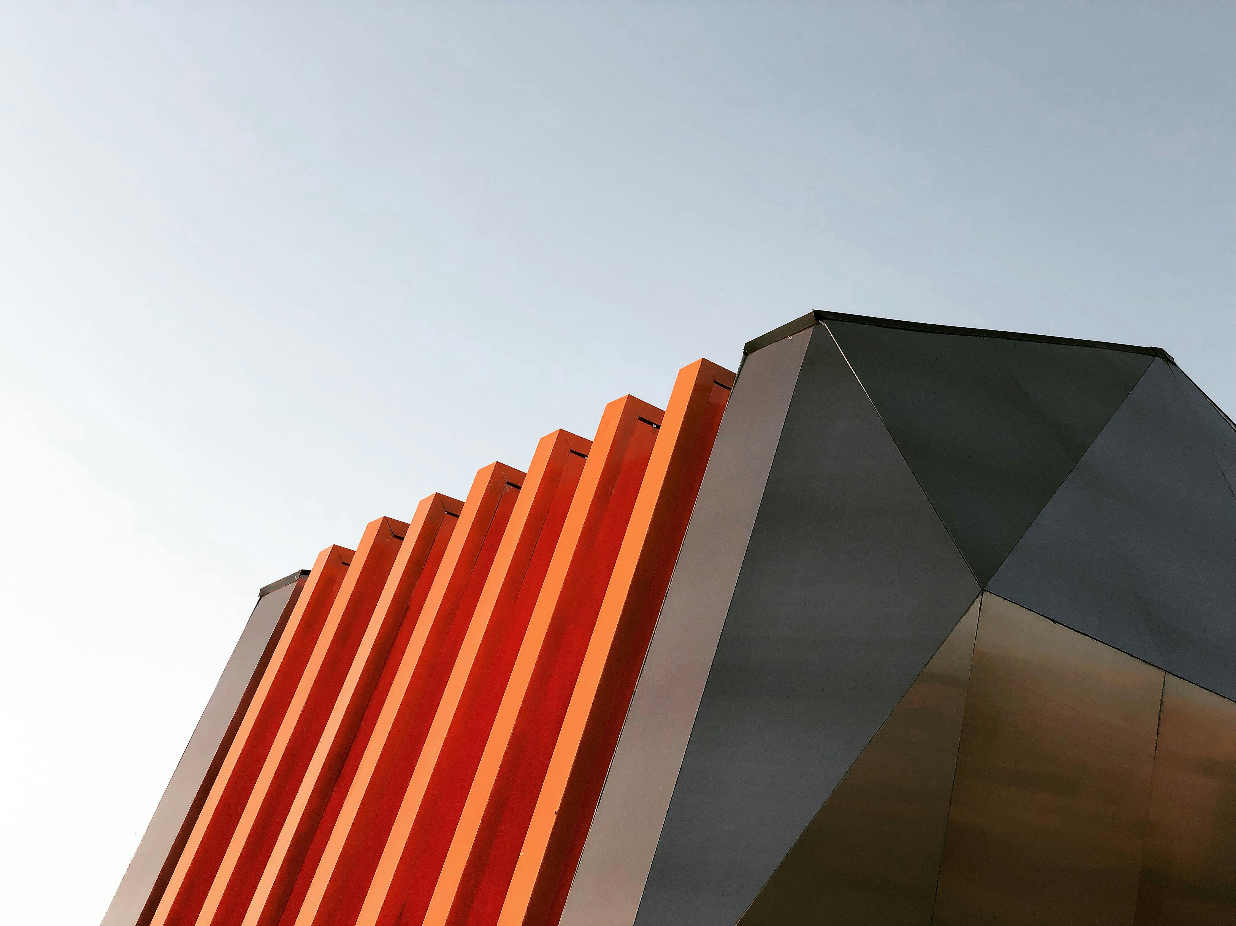 Closeup of modern architecture with red wall and metal accents.