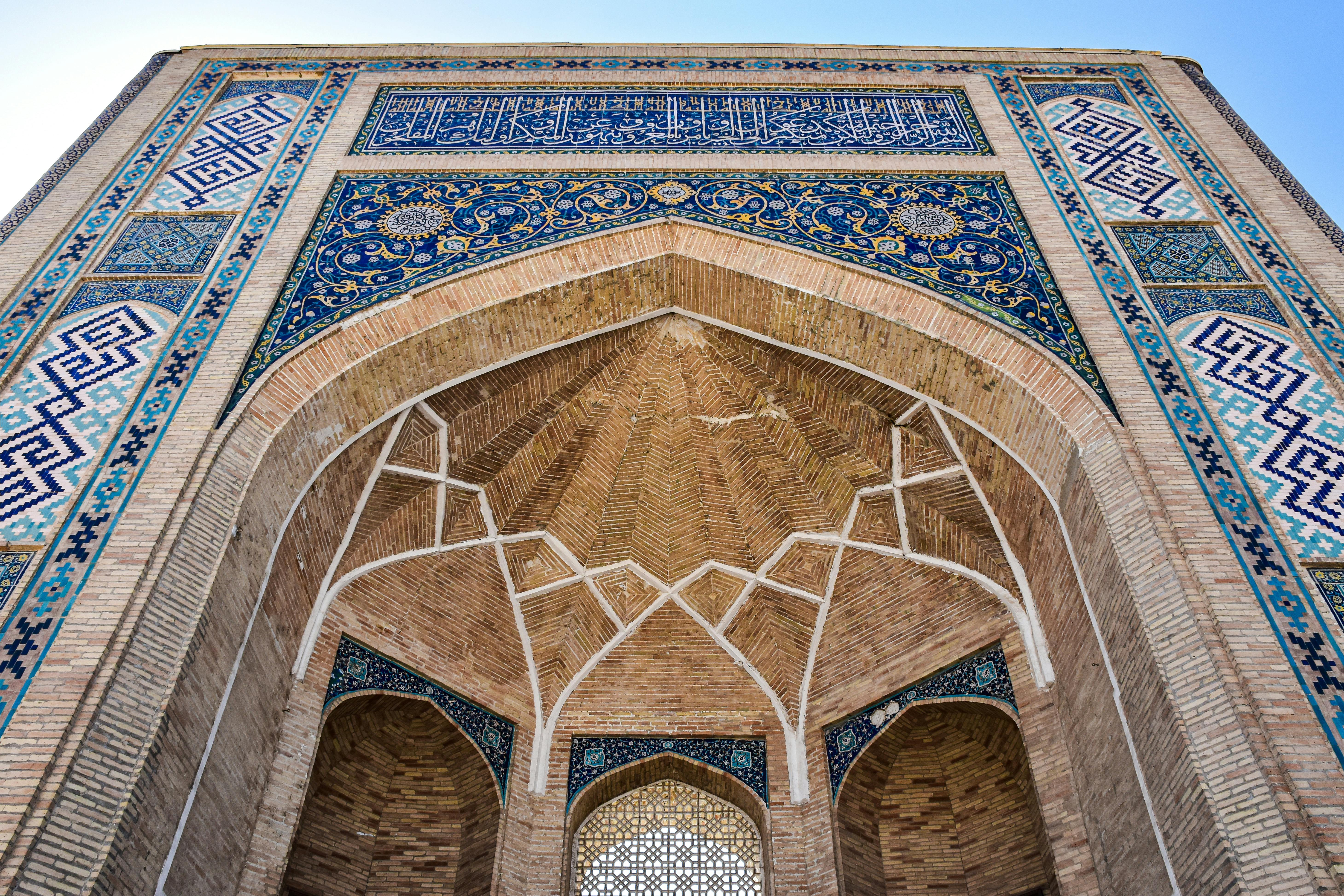 Ornate brick and tile entrance of Ulugh Beg Madrasa in Samarkand, Uzbekistan.
