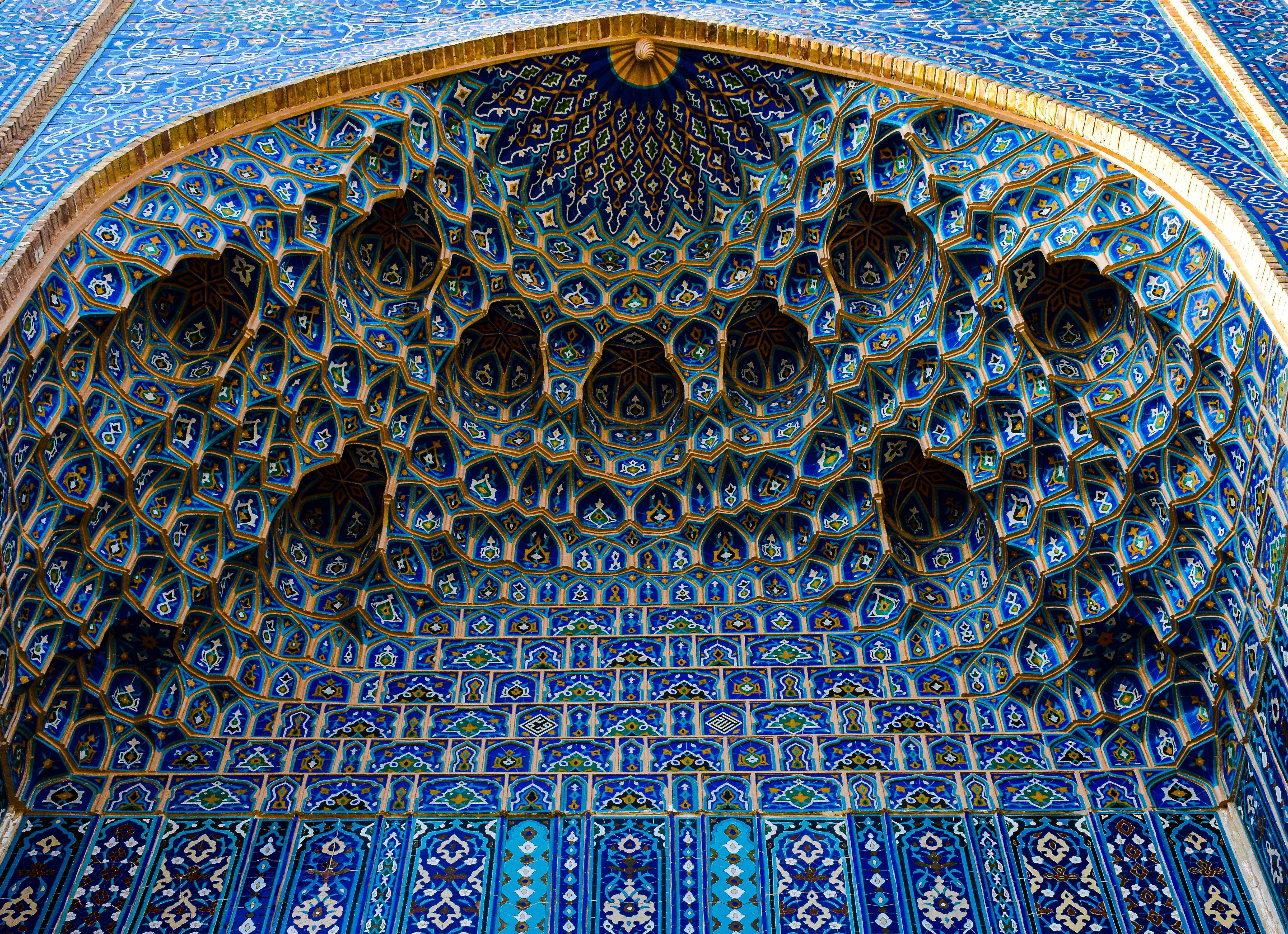 Blue ornamented mosaic with geometric patterns on a building in Uzbekistan.
